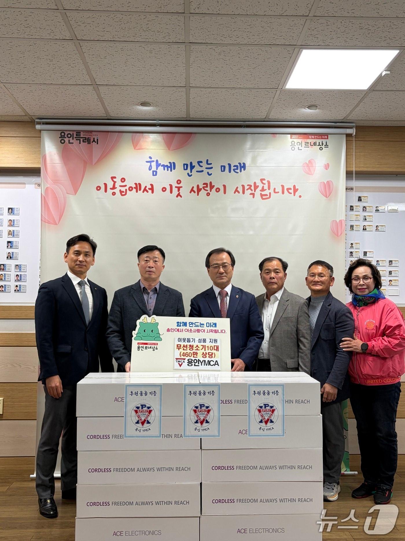 본문 이미지 - 김명돌 이사장(왼쪽 3번째) 등 용인YMCA 관계자들이 24일 용인시 이동읍 행정복지센터에서 취약계층을 위해 써달라며 청소기 10대를 전달하고 있다.(용인YMCA 제공)