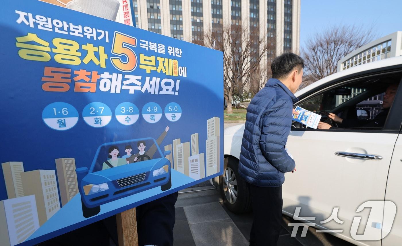 본문 이미지 - 25일 서울 종로구 정부서울청사 앞에서 청사 직원들이 원유 안보위기 ‘주의’ 경보 발령에 따른 공공 차량 5부제 캠페인을 벌이고 있다.  2026.3.25 ⓒ 뉴스1 임세영 기자