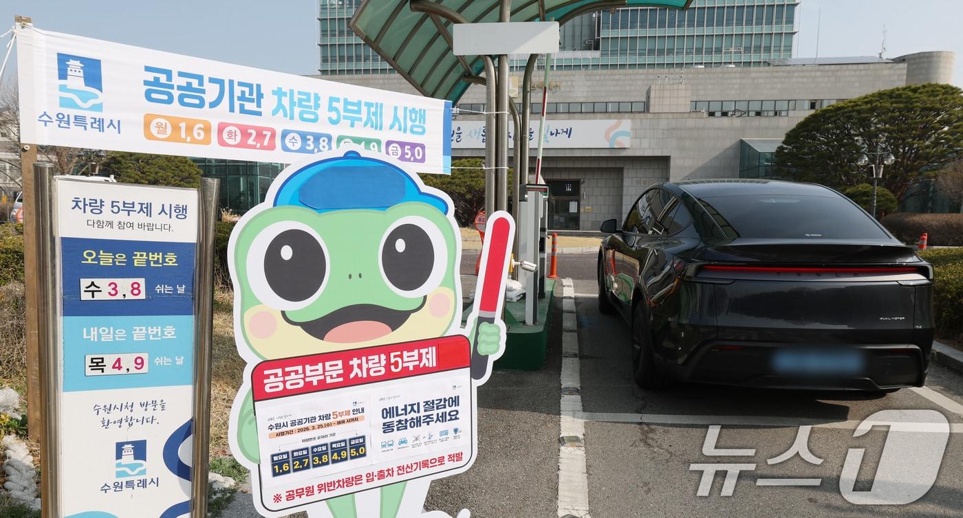 본문 이미지 - 25일 경기 수원시 팔달구 수원시청에서 직원들이 차량 5부제 시행 안내판이 설치돼 있다. 2026.3.25 ⓒ 뉴스1 김영운 기자