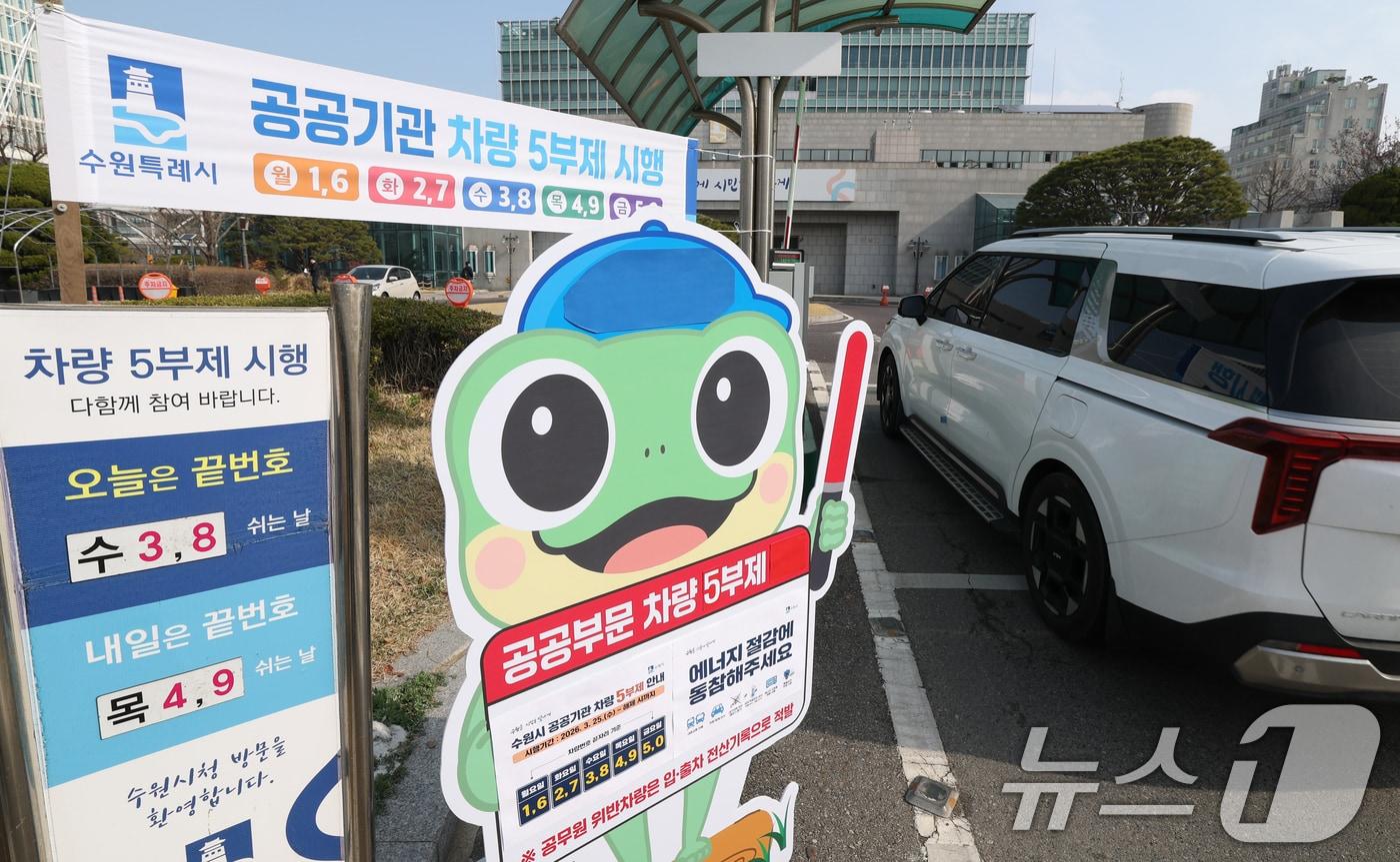 본문 이미지 - 25일 경기 수원시 팔달구 수원시청에서 직원들이 차량 5부제 시행 안내판이 설치돼 있다. 2026.3.25 ⓒ 뉴스1 김영운 기자