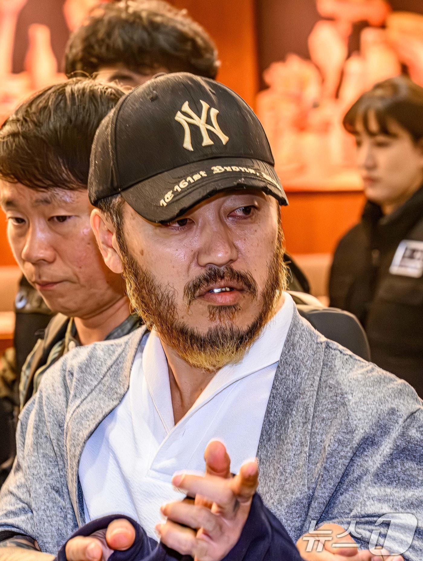 본문 이미지 - 필리핀에서 복역 중이던 이른바 ‘텔레그램 마약왕’ 박왕열(48)이 25일 오전 인천국제공항 제2터미널을 통해 국내로 송환되던 중 손짓하고 있다. (공동취재) 2026.3.25 ⓒ 뉴스1 안은나 기자