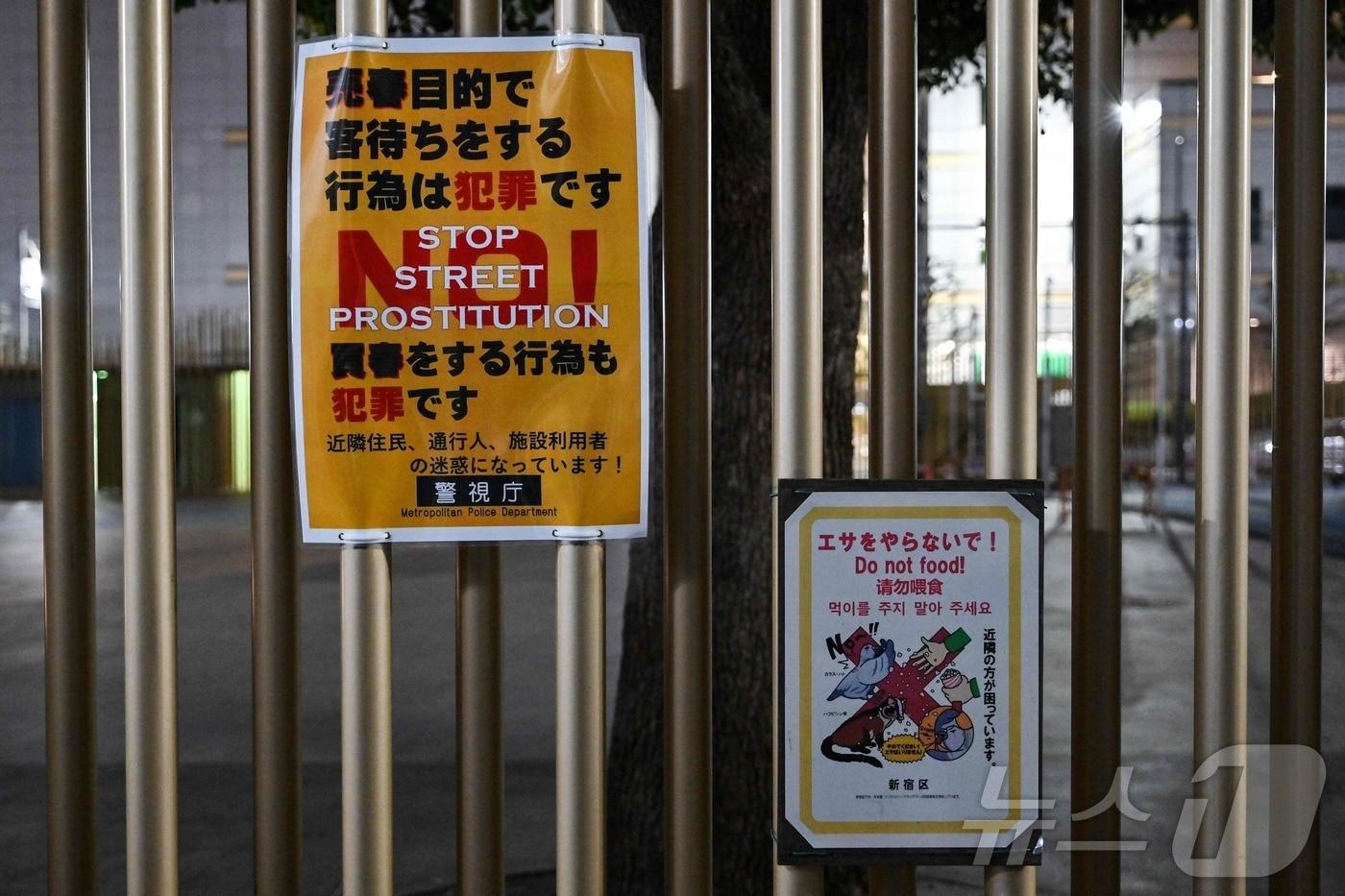 본문 이미지 - 2025년 3월 31일 도쿄 신주쿠구 가부키초 유흥가에 위치한 오쿠보 공원에 길거리 성매매에 대해 경고하는 경찰 안내문(왼쪽)이 붙어 있다. 2025.03.31. ⓒ AFP=뉴스1