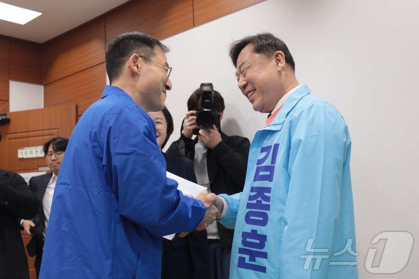 본문 이미지 - 울산시장 선거에 나서는 더불어민주당 김상욱 의원과 진보당 김종훈 전 동구청장이 25일 울산시의회 프레스센터에서 만나 악수하고 있다. ⓒ 뉴스1 김세은 기자