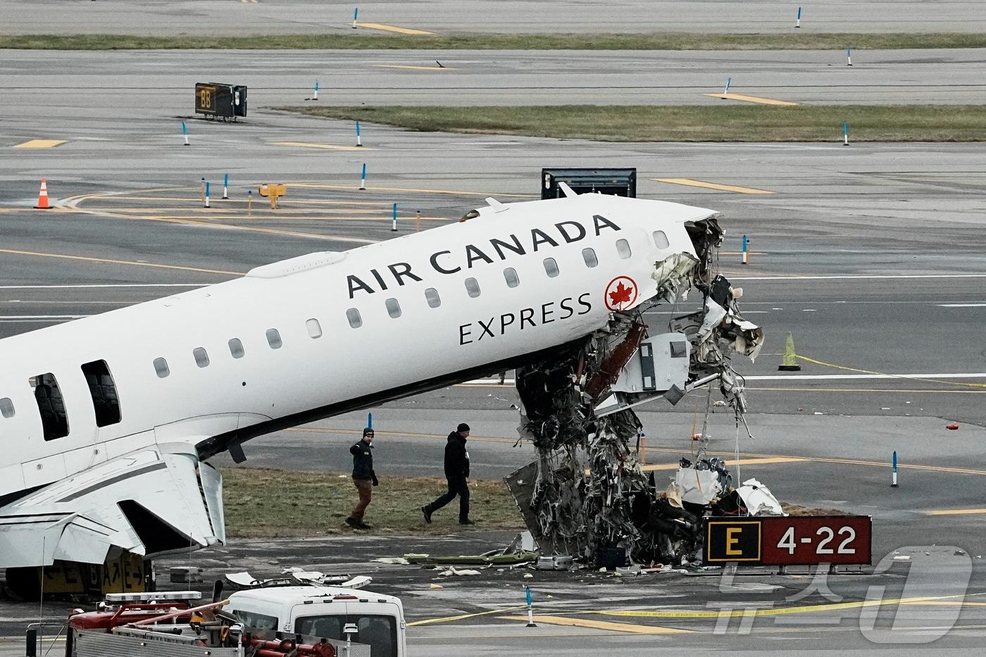 본문 이미지 - 미 연방교통안전위원회(NTSB) 요원들이 지난 23일(현지시간) 뉴욕 라과디아 공항에서 에어캐나다 익스프레스 여객기의 잔해를 조사하고 있다. ⓒ 로이터=뉴스1