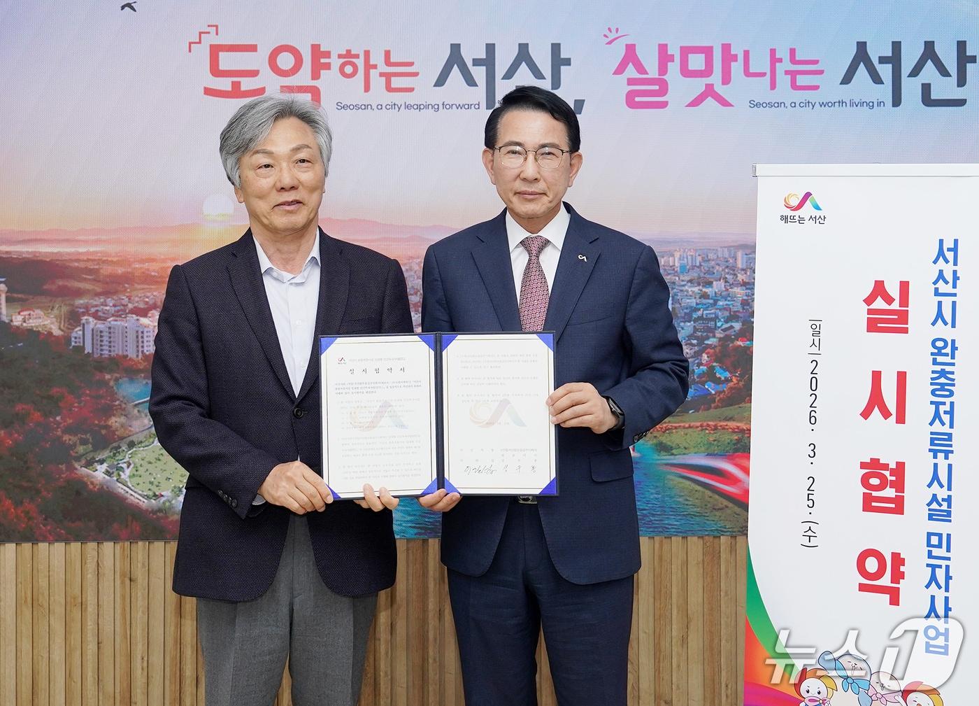 본문 이미지 - 지난 25일 서산시청 시장실에서 이완섭 시장(오른쪽)과 성우종 ㈜도원이엔씨 회장이 완충저류시설 설치 실시협약을 맺고 기념촬영을 하고 있다.(서산시 제공. 재판매 및 DB금지)2026.3.26/뉴스1