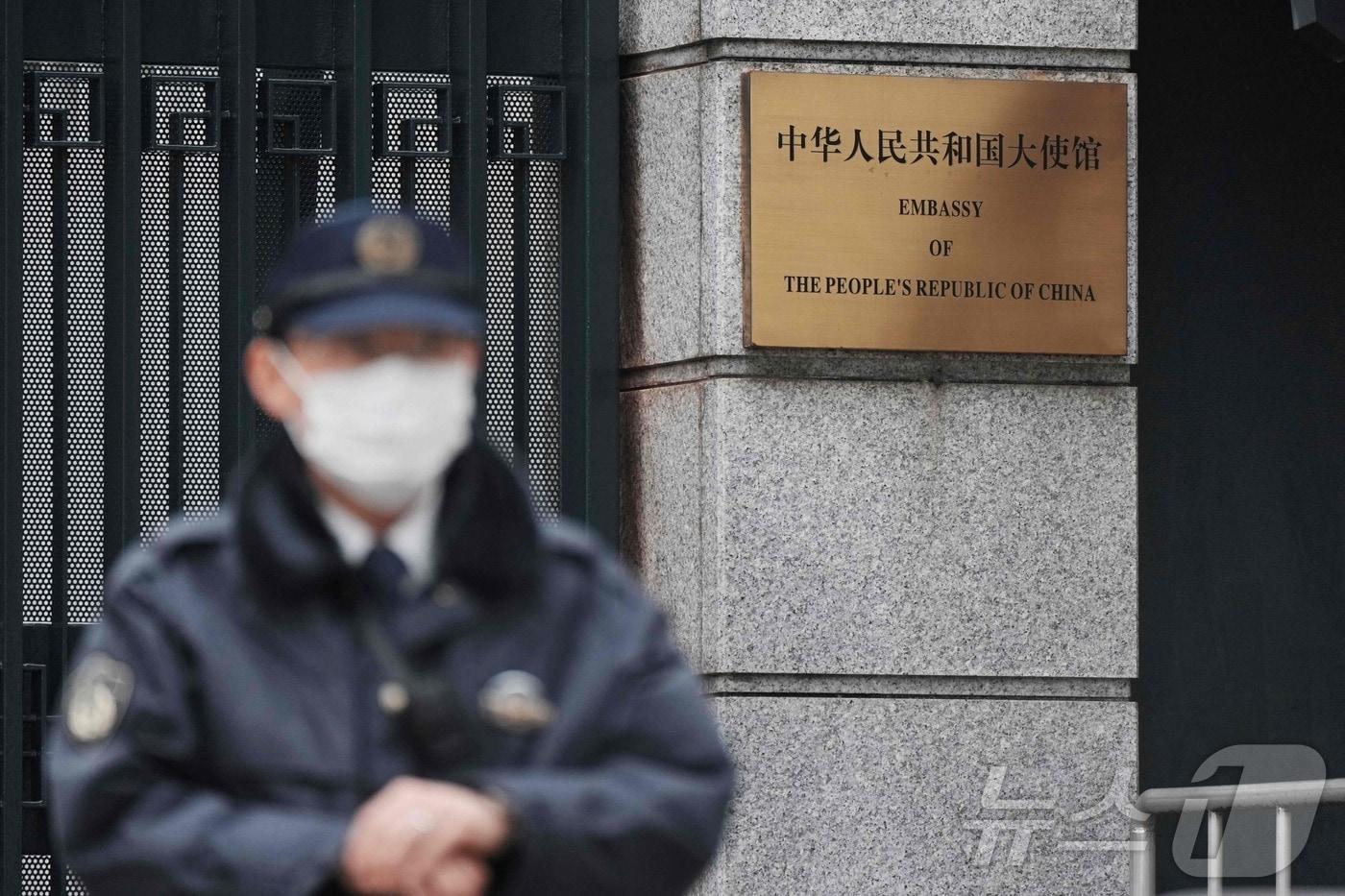 본문 이미지 - 25일 일본 도쿄 주재 중국 대사관 입구에서 경찰관이 경비를 서고 있다. 전날 한 자위대원이 대사관 경내에 무단 침입한 혐의로 체포됐다. 2026.03.25. ⓒ AFP=뉴스1