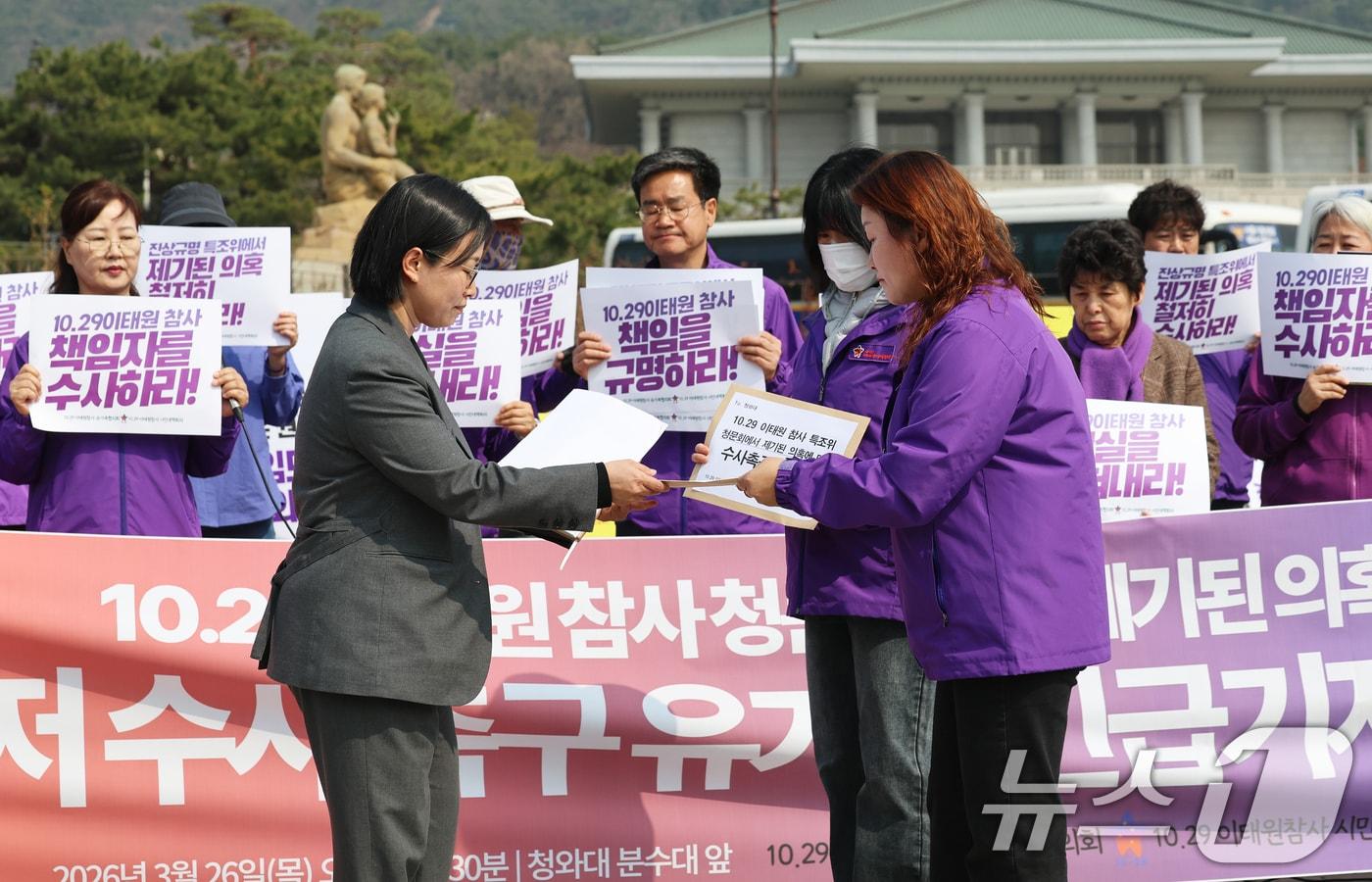 본문 이미지 - 10.29이태원참사 유가족들이 26일 서울 종로구 청와대 분수대 앞에서 열린 '이태원참사 청문회 제기 의혹 철저 수사 촉구 기자회견'에서 청와대 국민통합비서관실 조우경 행정관에게 수사 촉구 의견서를 제출하고 있다. 2026.3.26 ⓒ 뉴스1 오대일 기자
