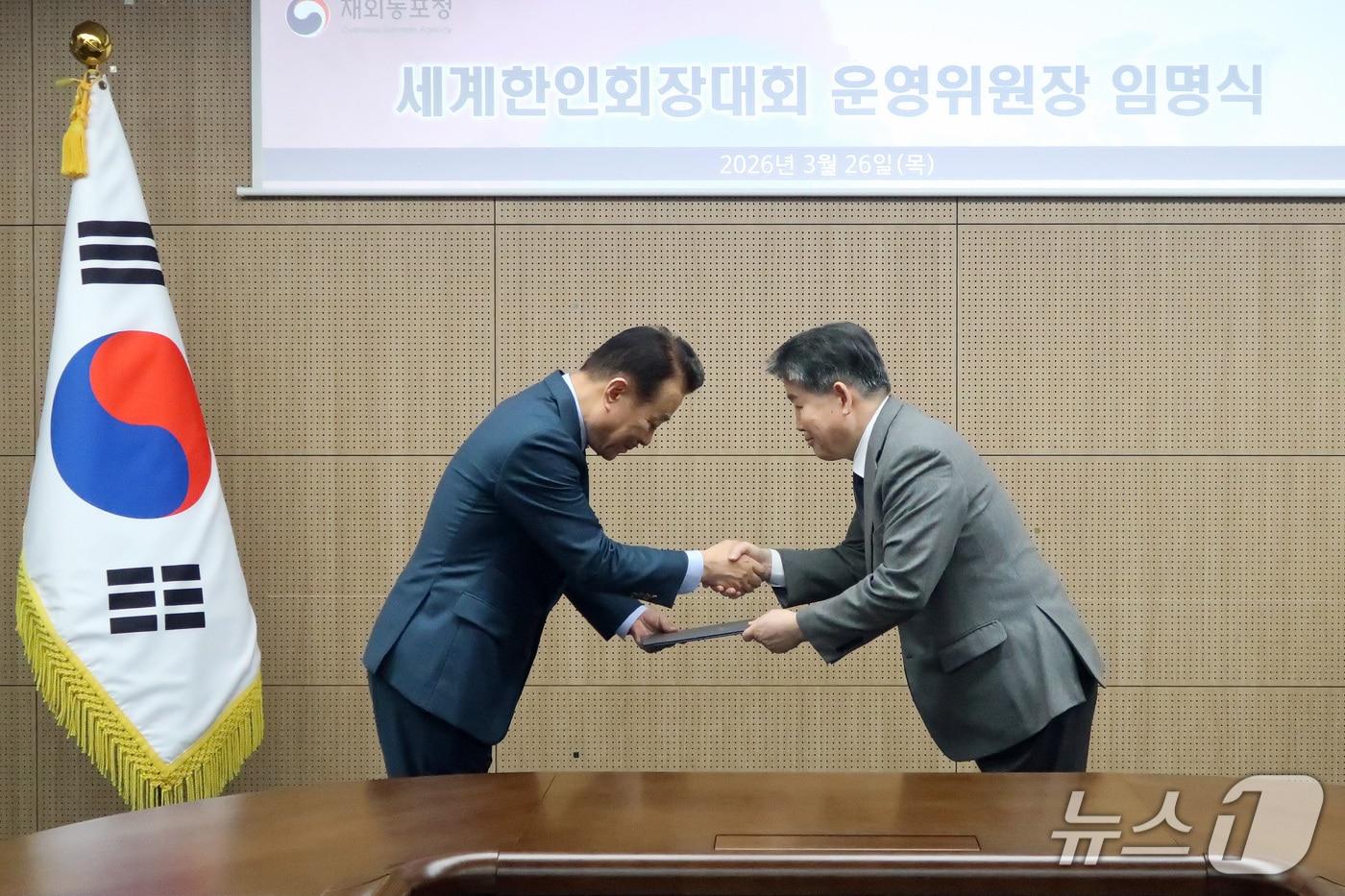 본문 이미지 -  김경협 재외동포청장이 26일 서울에서 열린 신임 세계한인회장대회 운영위원장 임명식에서 고상구 세계한인총연합회 회장에게 임명장을 수여하고 있다. 2026.03.26. (재외동포청 제공)