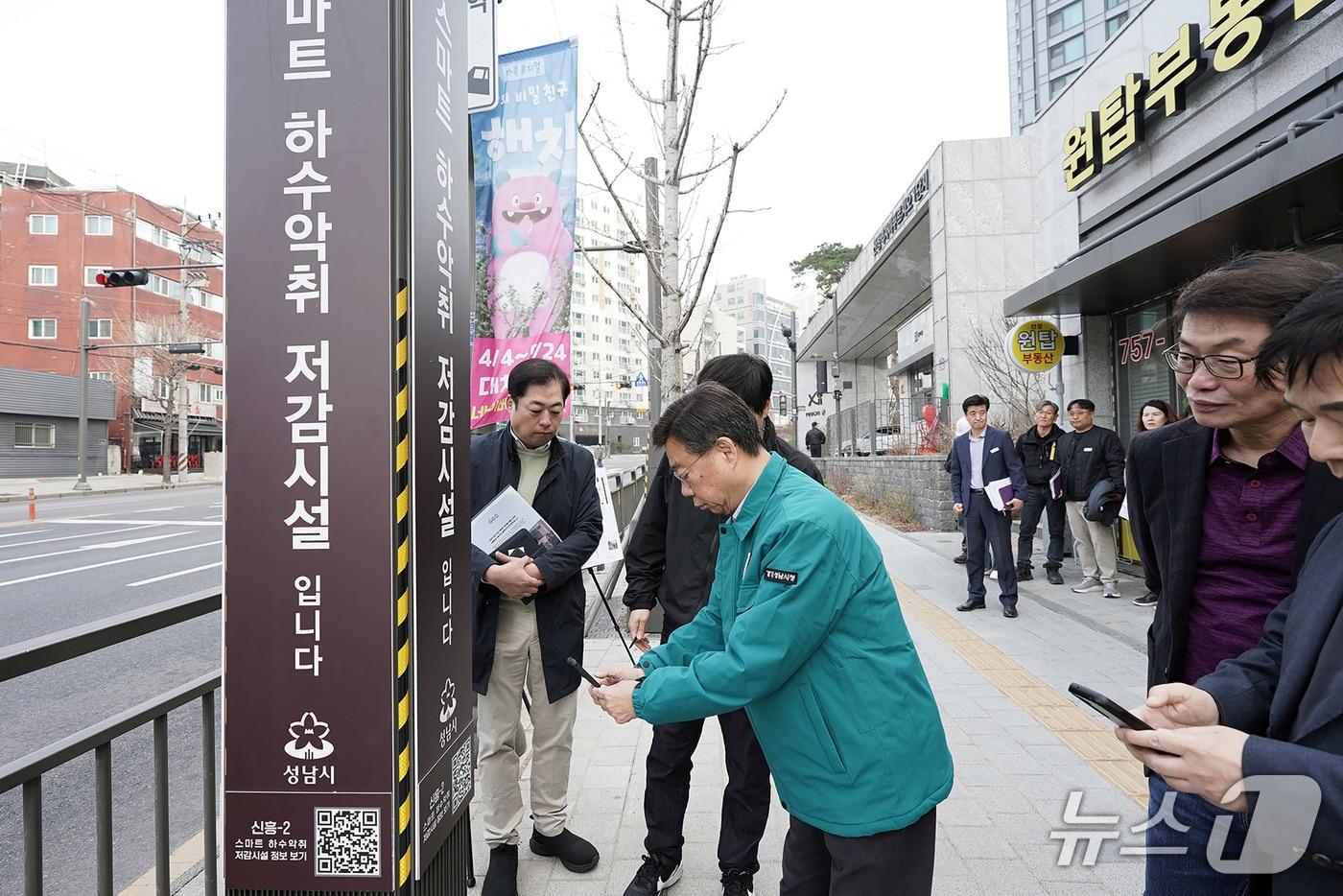 본문 이미지 - 지난 26일 신상진 경기 성남시장이 악취 농도 측정 결과 확인을 위해 신흥2동 스마트 하수 악취 저감시설에 부착된 큐알(QR)코드를 스마트폰으로 스캔 중이다.(성남시 제공. 재판매 및 DB금지)/뉴스1