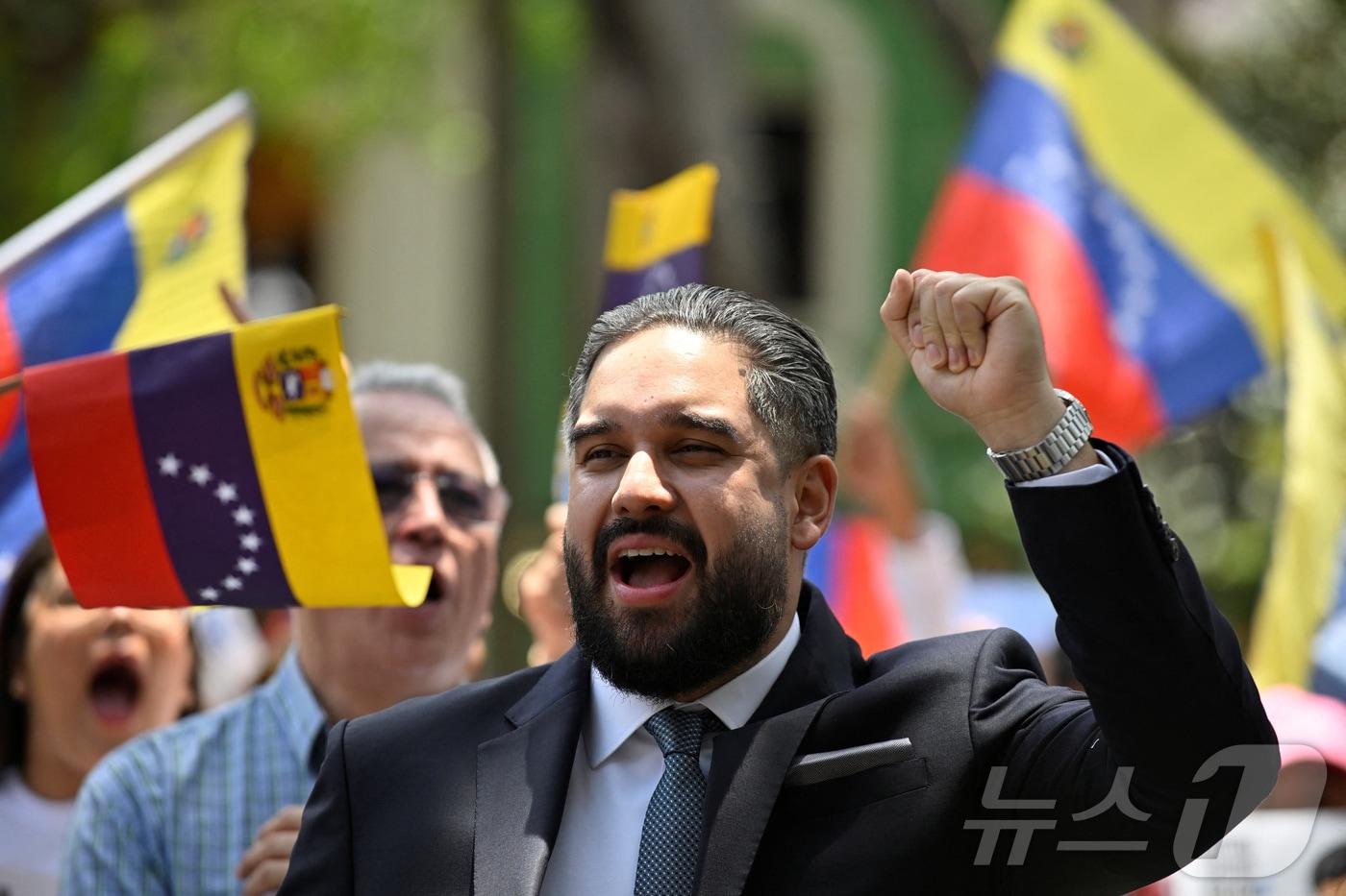 본문 이미지 - 니콜라스 마두로 전 베네수엘라 대통령의 아들인 니콜라스 마두로 게라가 26일(현지시간) 아버지를 지지하기 위해 모인 사람들 앞에서 주먹을 들어올리고 있다. 2026.3.26. ⓒ 뉴스1 ⓒ 로이터=뉴스1