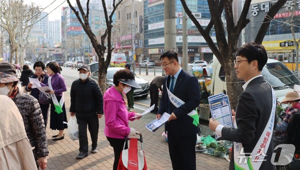 본문 이미지 - 27일 대구농협 직원들이 금요직거래장터를 찾은 방문객들을 대상으로 보이스피싱 보상 보험 무료 가입을 안내하는 전단지를 나눠주고 있다.(대구농협 제공, 재판매 및 DB 금지)