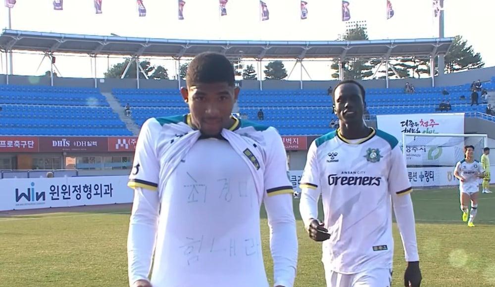 본문 이미지 - 안산 그리너스 FC 리마 선수가 3월 21일 K리그2 데뷔 첫 골을 넣은 뒤 유니폼을 들어 올리며 '최경미 힘내라'는 응원 문구를 보이고 있다.