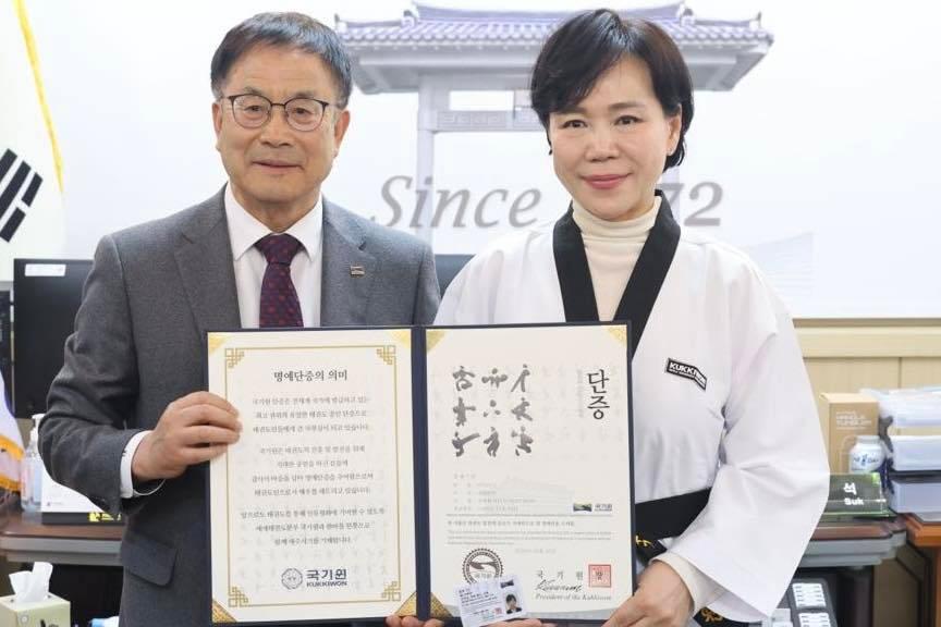 본문 이미지 -  전현희 의원(시계방향으로 오른쪽)이 태권도 명예 7단증을 보여주며 사진 촬영을 하고 있다.(전현희 의원 페이스북 갈무리)