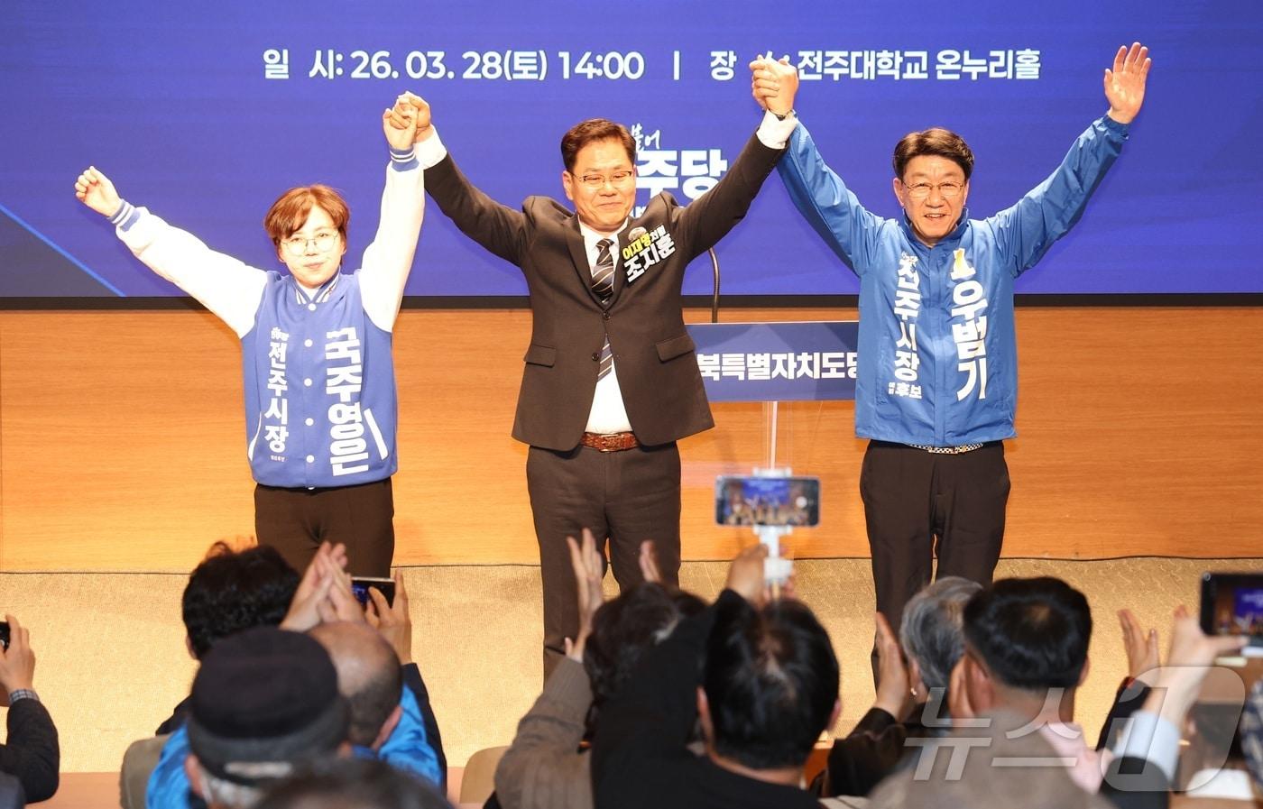 본문 이미지 - 28일 전북 전주시 전주대학교 온누리홀에서 열린 더불어민주당 전북특별자치도당 전주시장 후보자 선출을 위한 합동연설회에서 예비후보자들이 손을 맞잡고 기념촬영을 하고 있다. 왼쪽부터 국주영은, 조지훈, 우범기 예비후보. 2026.3.28 ⓒ 뉴스1 유경석 기자