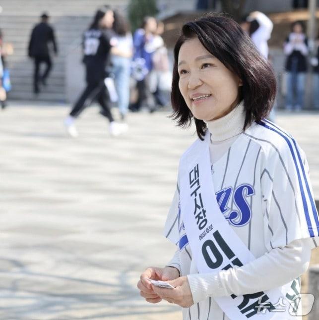 본문 이미지 -  '대구시장 예비후보 이진숙'이라는 어깨띠를 한 이진숙 전 방송통신위원장이 지난 28일 삼성라이온즈-롯데자이언츠와의 프로야구 대구 홈 개막전이 열린 대구라이온즈파크를 찾아 시민들에게 명함을 돌리고 함께 사진을 찍는 등 이름 알리기에 열중했다. (SNS 갈무리) ⓒ 뉴스1