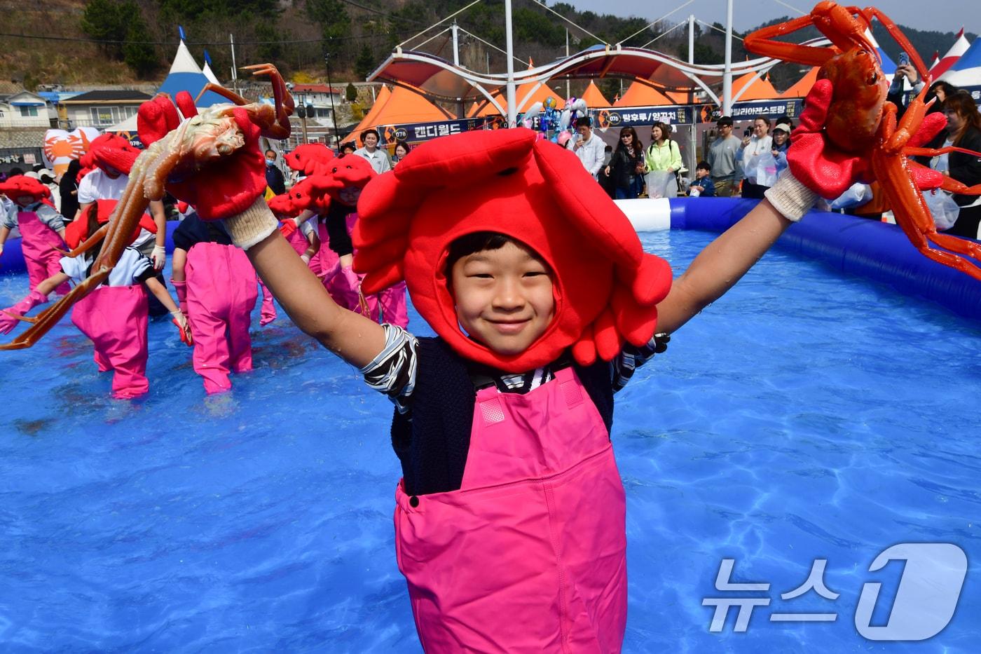본문 이미지 - 29일 제29회 경북 영덕대게축제가 열린 강구항 해파랑공원에서 가족과 함께 온 어린이가 대게 맨손잡기 체험에서 잡은 대게를 자랑하고 있다. 2026.3.29 ⓒ 뉴스1 최창호 기자