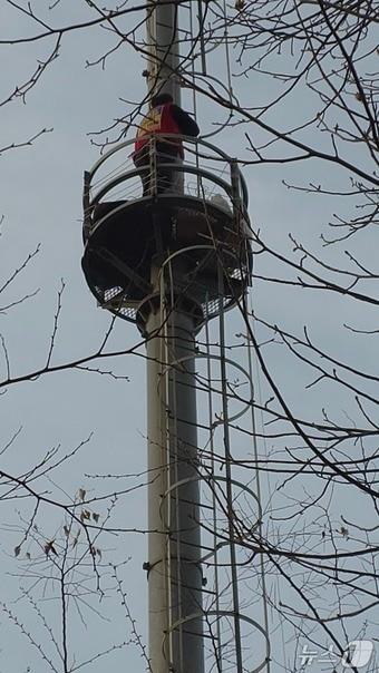 본문 이미지 - 택시노동자 고영기 씨가 맹성규 더불어민주당 의원 사무실 앞 통신탑에 올라가고 있다. (민주노총 공공운수노조 택시지부 제공)