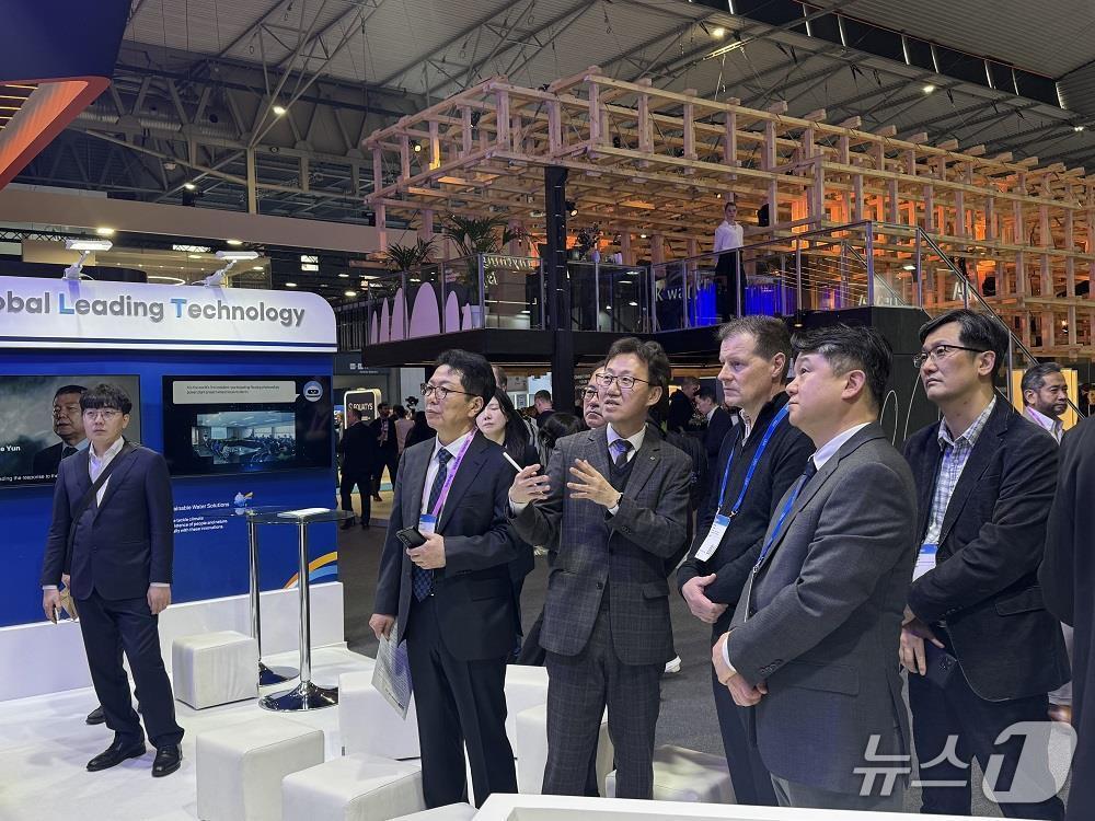 본문 이미지 - MWC 2026에서 한국수자원공사 관계자가 K-water관을 찾은 외국인 방문객에게 물관리 디지털트윈 등 AI 기반 최첨단 물관리 기술을 설명하고 있다.(한국수자원공사 제공.재판매 및 DB금지)/뉴스1