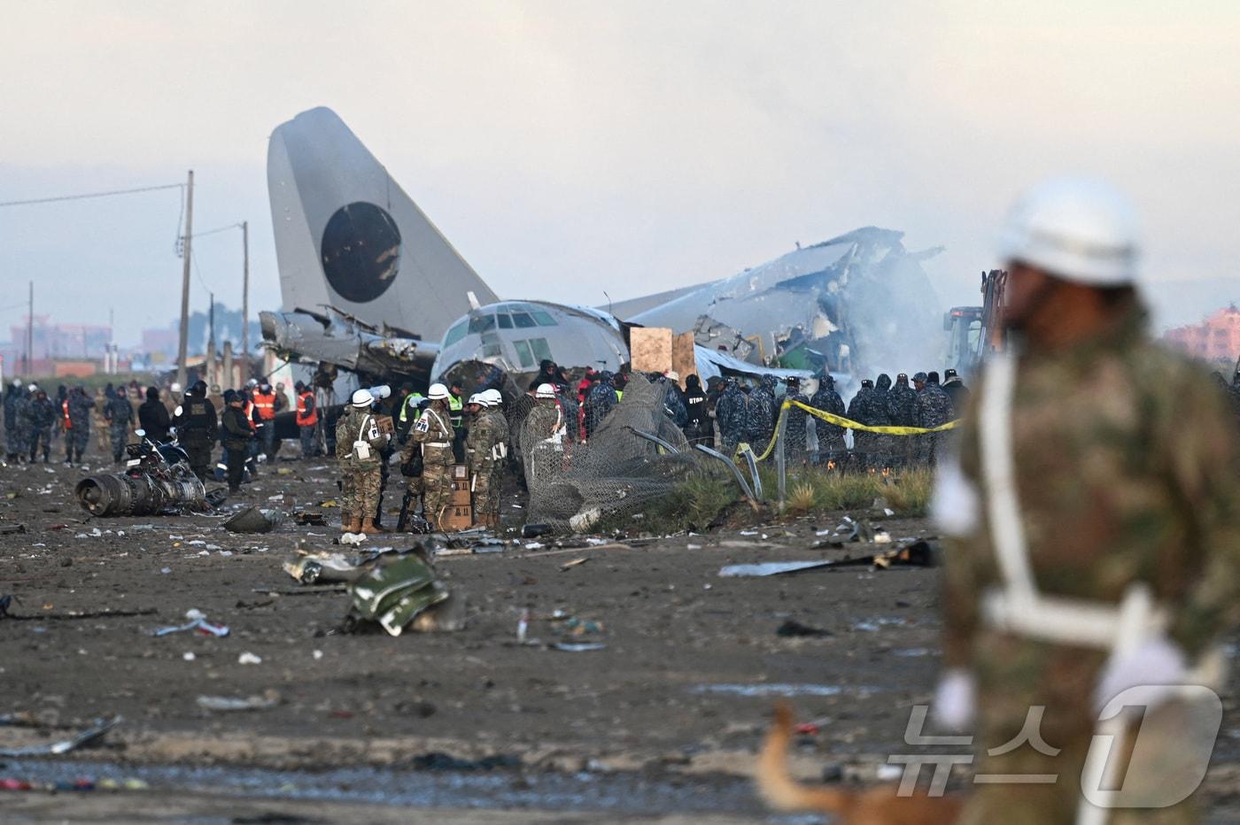 본문 이미지 - 28일(현지시간) 볼리비아 엘알토에서 악천후 속에 볼리비아 공군 소속 허큘리스 항공기가 번화한 대로로 추락한 뒤 긴급 구조 요원들이 현장에서 작업을 벌이고 있다. 2026. 02. 28. ⓒ 로이터=뉴스1