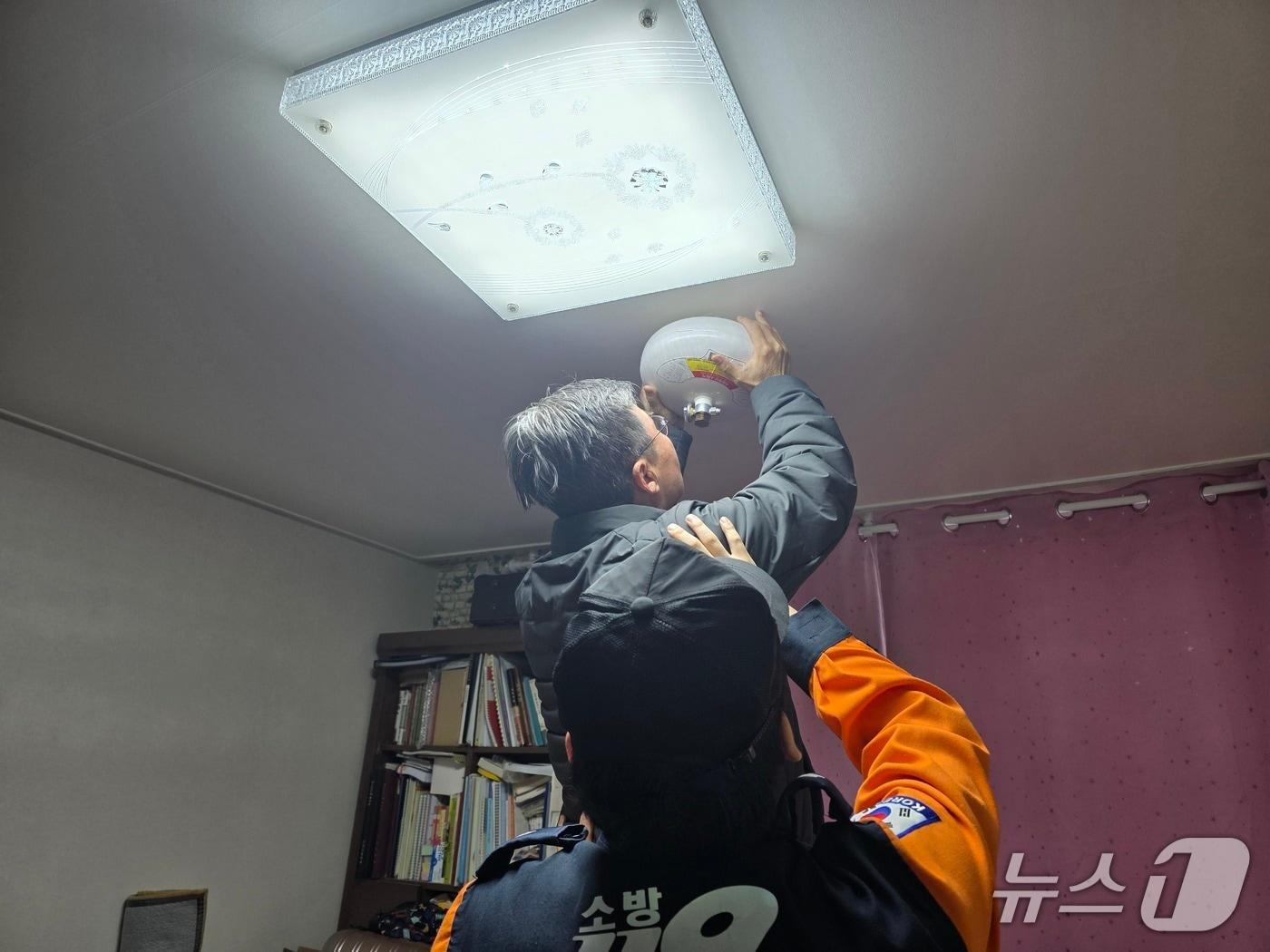 본문 이미지 - 경기 안양소방서 관계자들이 만안구 삼익악파트 화재취약계층 세대를 상대로 자동확산소화기 설치를 지원하고 있다. (안양소방 제공. 재판매 및 DB 금지) 2026.3.3/뉴스1