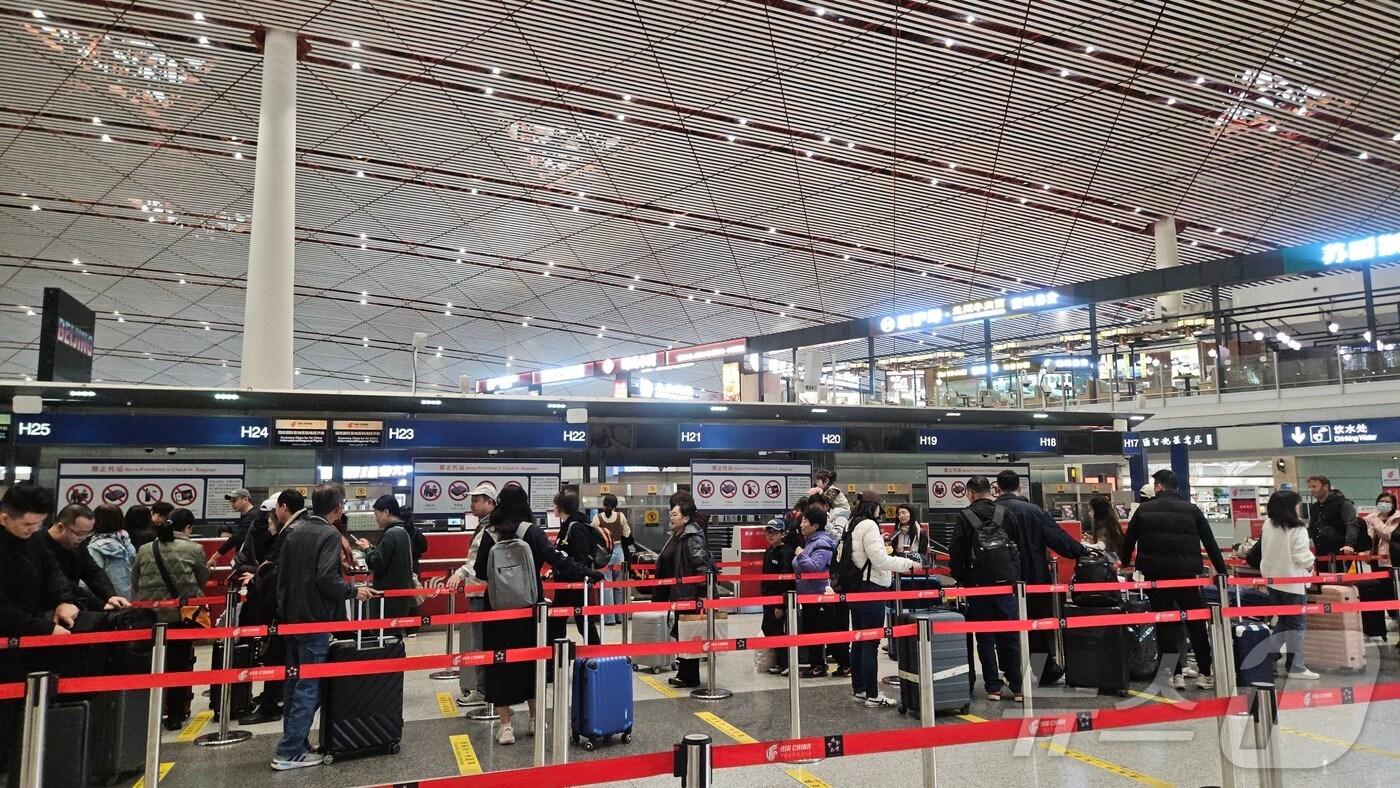 30일 오전 중국 베이징 서우두공항 제3터미널에서 베이징~평양 노선을 포함한 주요 국제선 노선 탑승 수속 카운터에 사람들이 줄을 서 있다. ⓒ 뉴스1 정은지 특파원