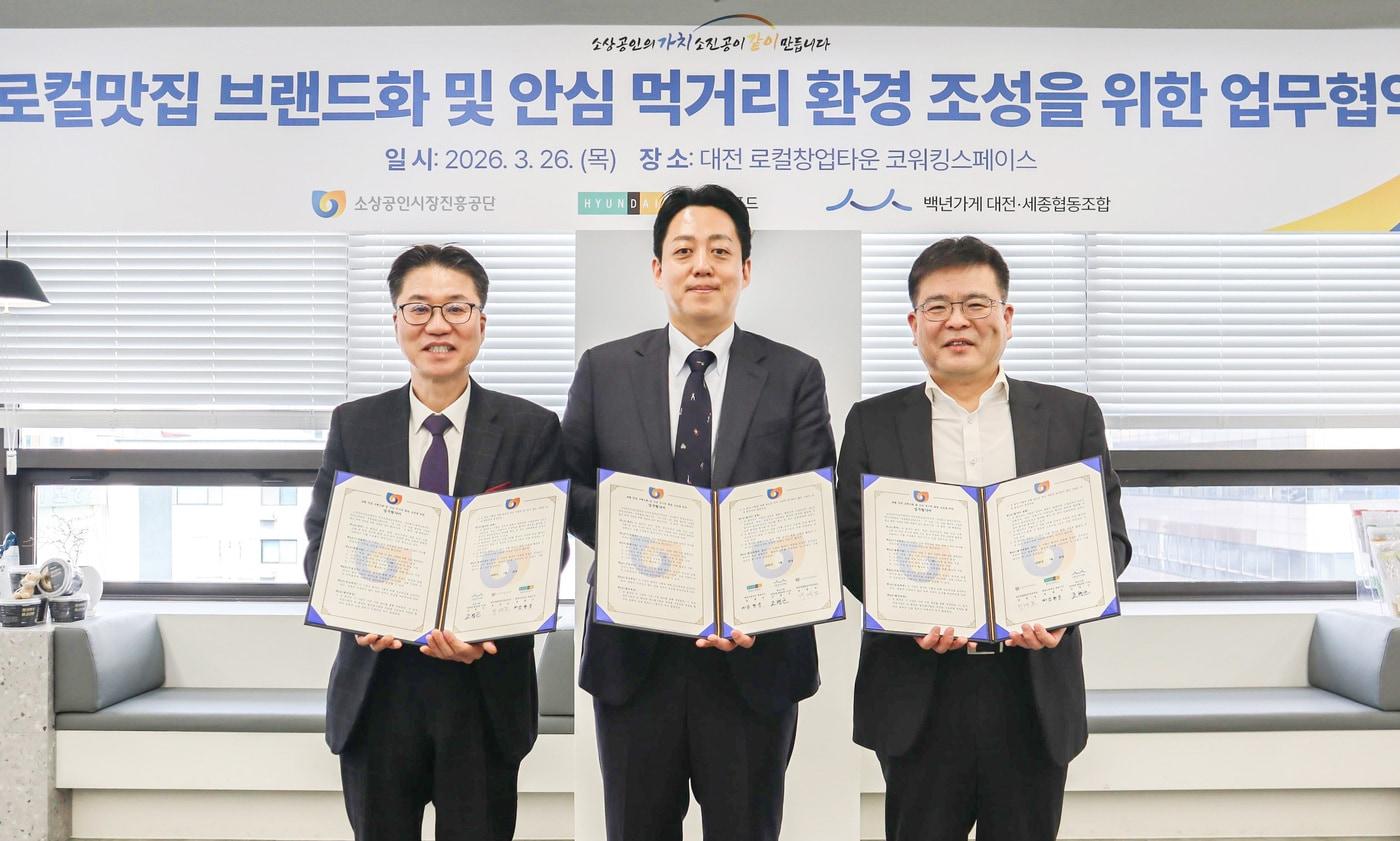 본문 이미지 - 대전광역시 중구 로컬창업타운에서 진행된 '로컬맛집 브랜드화 및 안심 먹거리 환경 조성을 위한 업무협약' 협약식에서 김현준 현대그린푸드 식품구매사업부장(상무, 오른쪽)과 박경모 소상공인시장진흥공단 대전세종충남본부장(왼쪽), 조병근 백년가게대전세종협동조합 이사장(가운데)이 기념사진을 촬영하고 있는 모습.(현대그린푸드 제공)