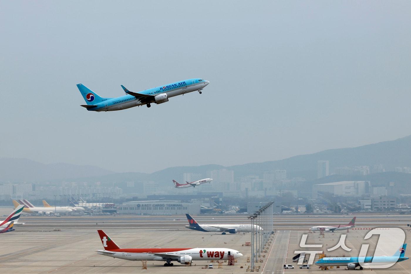 본문 이미지 -  인천국제공항 계류장에 대기하는 항공기 앞으로 대한항공과 티웨이 항공기가 이륙하고 있다. 2026.3.30 ⓒ 뉴스1 박정호 기자
