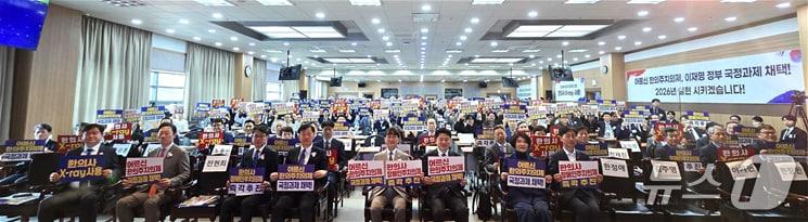 본문 이미지 - 지난 29일 대한한의사협회 대강당에서 열린 제70회 정기대의원총회에서 참석자들이 피켓을 들고 있는 모습. (한의협 제공)