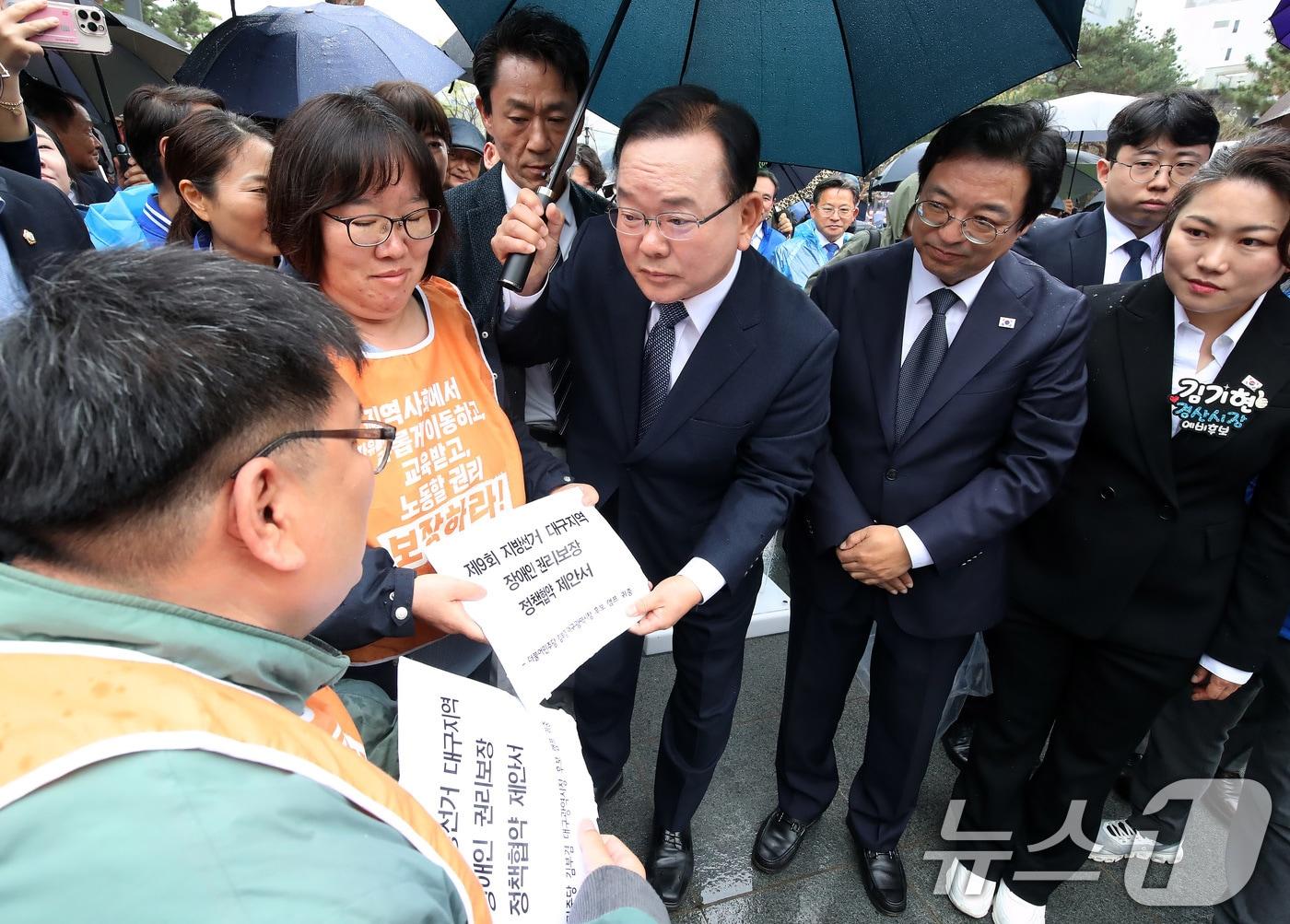 본문 이미지 - 김부겸 전 국무총리가 지난 달 30일 오후 대구 중구 2·28기념중앙공원에서 6·3지방선거 대구시장 출마 선언 기자회견을 마친 뒤 지역 장애인단체의 장애인 권리보장 정책협약 제안서를 전달받고 있다. 2026.3.30 ⓒ 뉴스1 공정식 기자