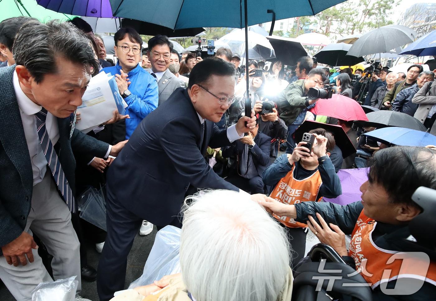 본문 이미지 - 김부겸 전 국무총리가 30일 오후 대구 중구 2·28기념중앙공원에서 6·3지방선거 대구시장 출마 선언 기자회견을 마친 뒤 지역 장애인단체의 장애인 권리보장 정책협약 제안서를 전달받고 있다. 2026.3.30 ⓒ 뉴스1 공정식 기자