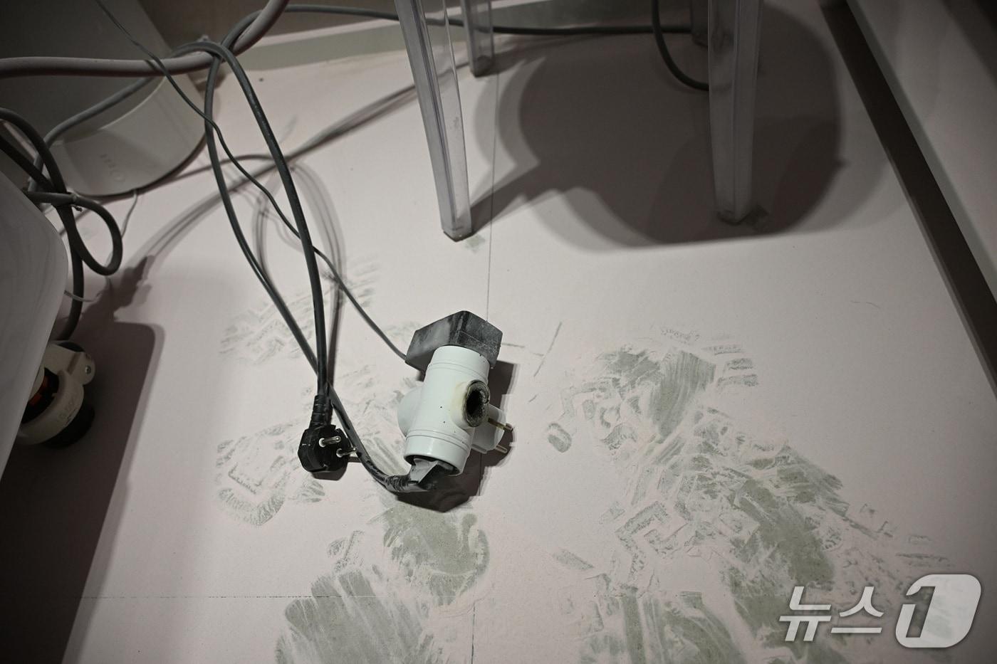 본문 이미지 - 단락으로 불이 난 콘센트. 바닥에 소화기 분진이 뿌려져 있다.(대전시 제공) /뉴스1