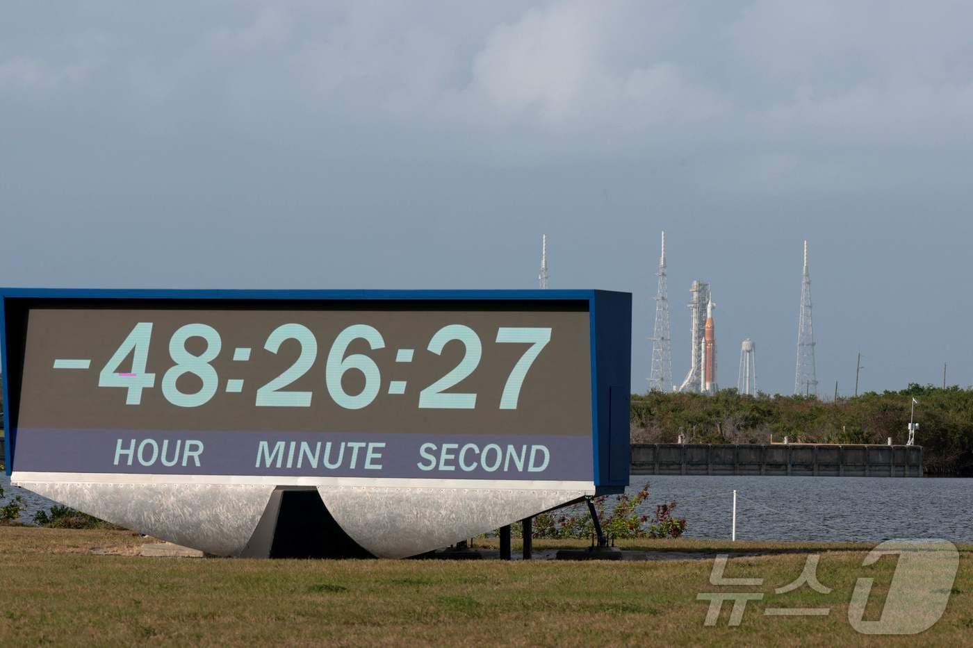 본문 이미지 - 30일(현지시간) 미국 항공우주국(NASA·나사)의 '아르테미스 II' 우주발사시스템(SLS) 로켓과 오리온 우주선이 케네디 우주센터 39B 발사대에 놓여 있고, 카운트다운 시계가 돌아가고 있다. 2026.03.30. ⓒ AFP=뉴스1