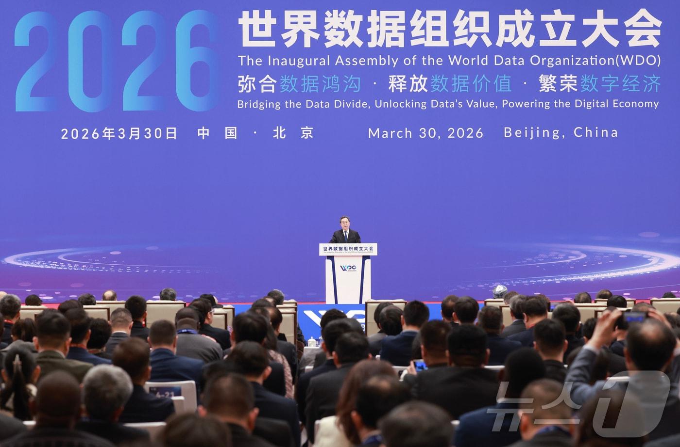 본문 이미지 - 딩쉐샹 중국 국무원 부총리가 30일 베이징에서 개최된 세계데이터기구(WDO) 총회에서 시진핑 주석의 기조연설을 대독하고 있다. 2026.3.30 ⓒ 신화=뉴스1