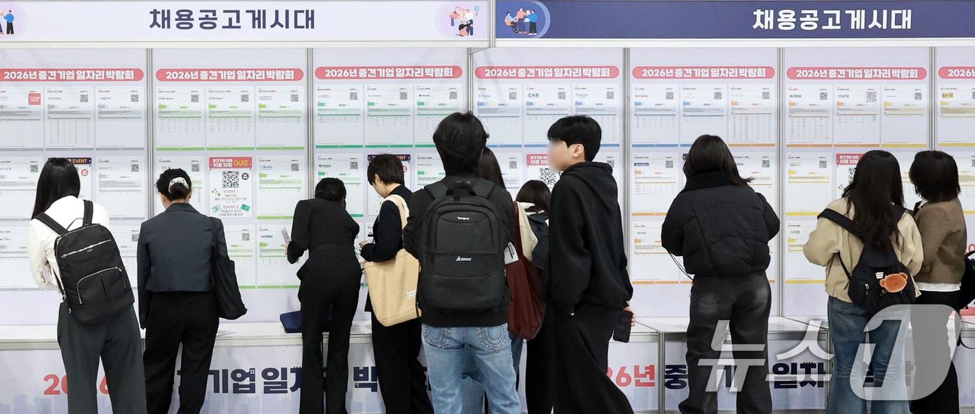 본문 이미지 - 서울 서초구 aT센터에서 열린 '2026년 중견기업 일자리박람회'를 찾은 구직자들이 채용공고게시대를 살펴보고 있다. ⓒ 뉴스1 이호윤 기자
