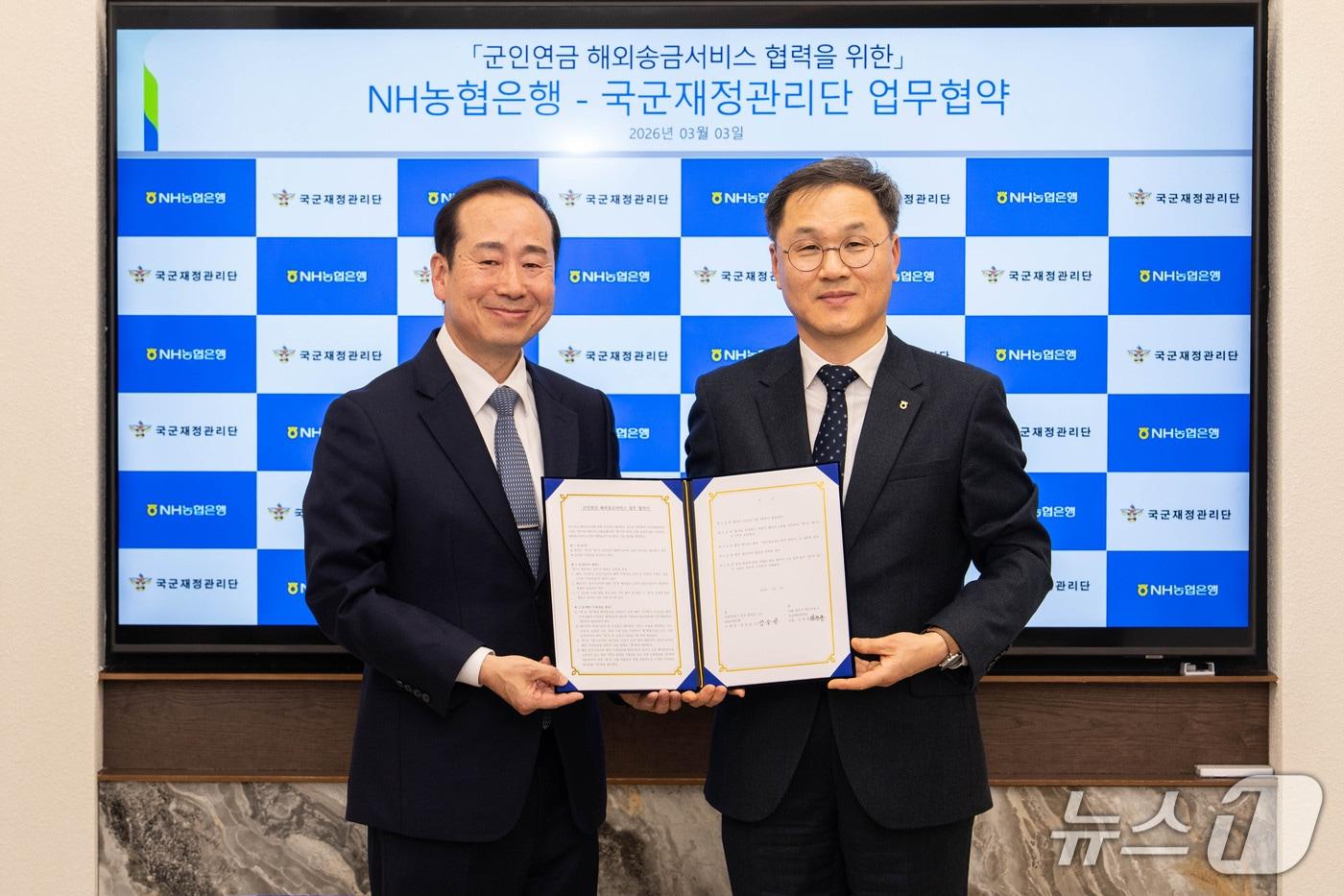 본문 이미지 - 지난 3일 엄을용 NH농협은행 기업금융부문 부행장(우)과 김천중 국군재정관리단장(좌)이 위탁계약 체결 후 기념사진 촬약을 하고 있다./ 26.03.04 사진제공=농협은행