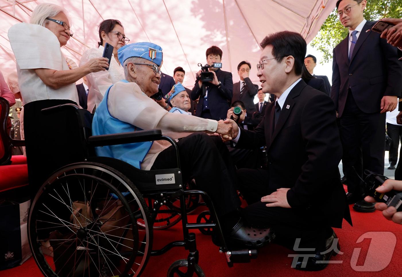 본문 이미지 - 필리핀을 국빈 방문한 이재명 대통령이 4일(현지시간) 필리핀 마닐라 영웅묘지를 찾아 한국전 참전기념비에 헌화를 마친 후 참전용사들과 인사를 나누고 있다. 2026.3.4 ⓒ 뉴스1 허경 기자