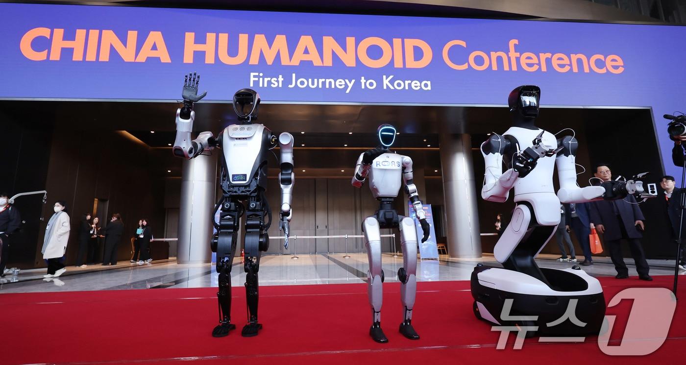 본문 이미지 - 4일 서울 강남구 코엑스에서 열린 ‘2026 스마트공장·자동화산업전(AW 2026)’에서 중국의 로봇 기업 레주로보틱스의 쿠아보(왼쪽부터), 유니트리의 G1, 에이지봇의 G2가 참관객을 향해 인사하고 있다. 2026.3.4 ⓒ 뉴스1 박지혜 기자