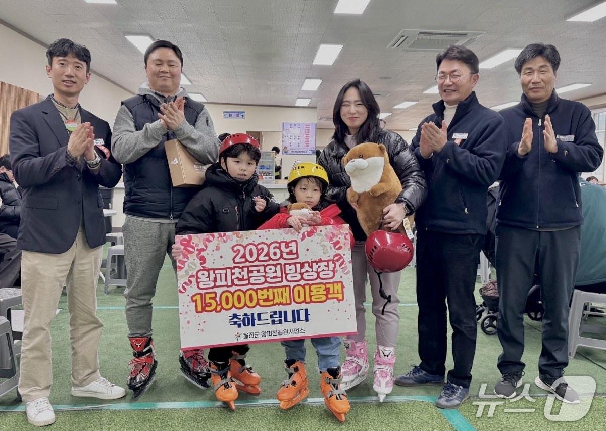본문 이미지 - 경북 울진군 왕피천공원 빙상장을 찾은 관광객이 17년 만에 1만5000명을 돌파했다. 울진군이 1만5000번째 관광객에게 선물을 전달하고 있다.(울진군 제공, 재판매 및 DB금지) 2026.3.4/뉴스1  