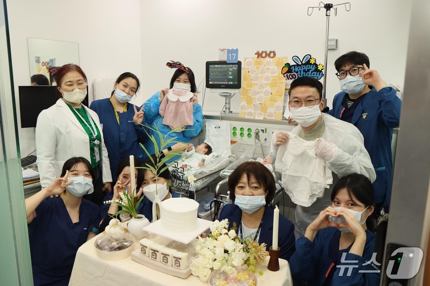 본문 이미지 - 초극소저체중아 쌍둥이 자매의 100일을 맞아 일산차병원 신생아집중치료실 의료진과 부모가 함께 기념 촬영을 하고 있다.(차 의과학대 일산차병원 제공)