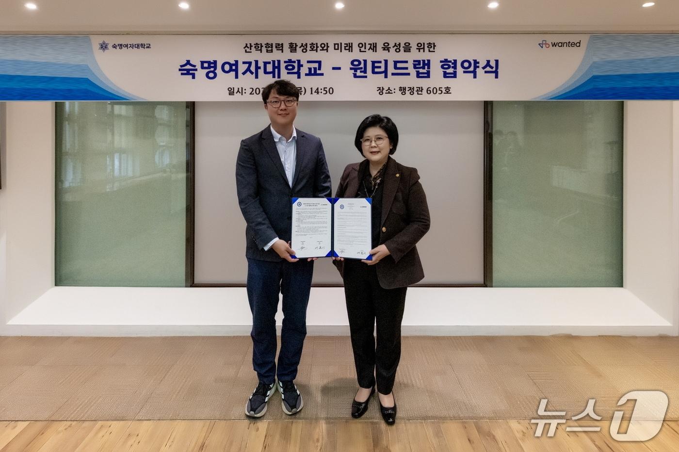 본문 이미지 - 숙명여대 행정관에서 열린 숙명여자대학교-원티드랩 업무협약식에서 문시연 총장(오른쪽)과 이복기 원티드랩 대표가 기념 촬영을 하고 있다.(숙명여대 제공)