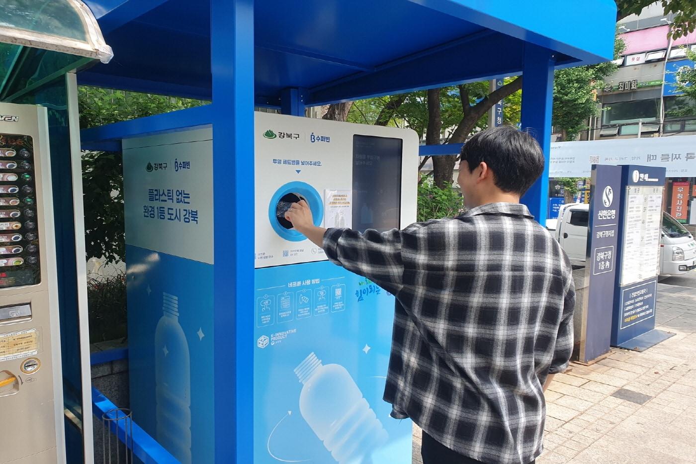 본문 이미지 - 한 구민이 투명페트병 무인회수기에 페트병을 투입하고 있다.(강북구 제공)