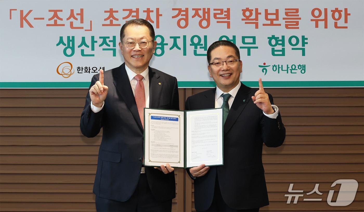 본문 이미지 - 하나은행은 지난 5일 한화오션과 'K-조선 초격차 경쟁력 확보'를 위한 업무협약을 체결했다. 이날 협약식에 참석한 이호성 하나은행장(사진 오른쪽)이 김희철 한화오션 대표이사(사진 왼쪽)와 협약서를 들고 기념촬영을 하고 있다. / 26.03.06 사진제공=하나은행