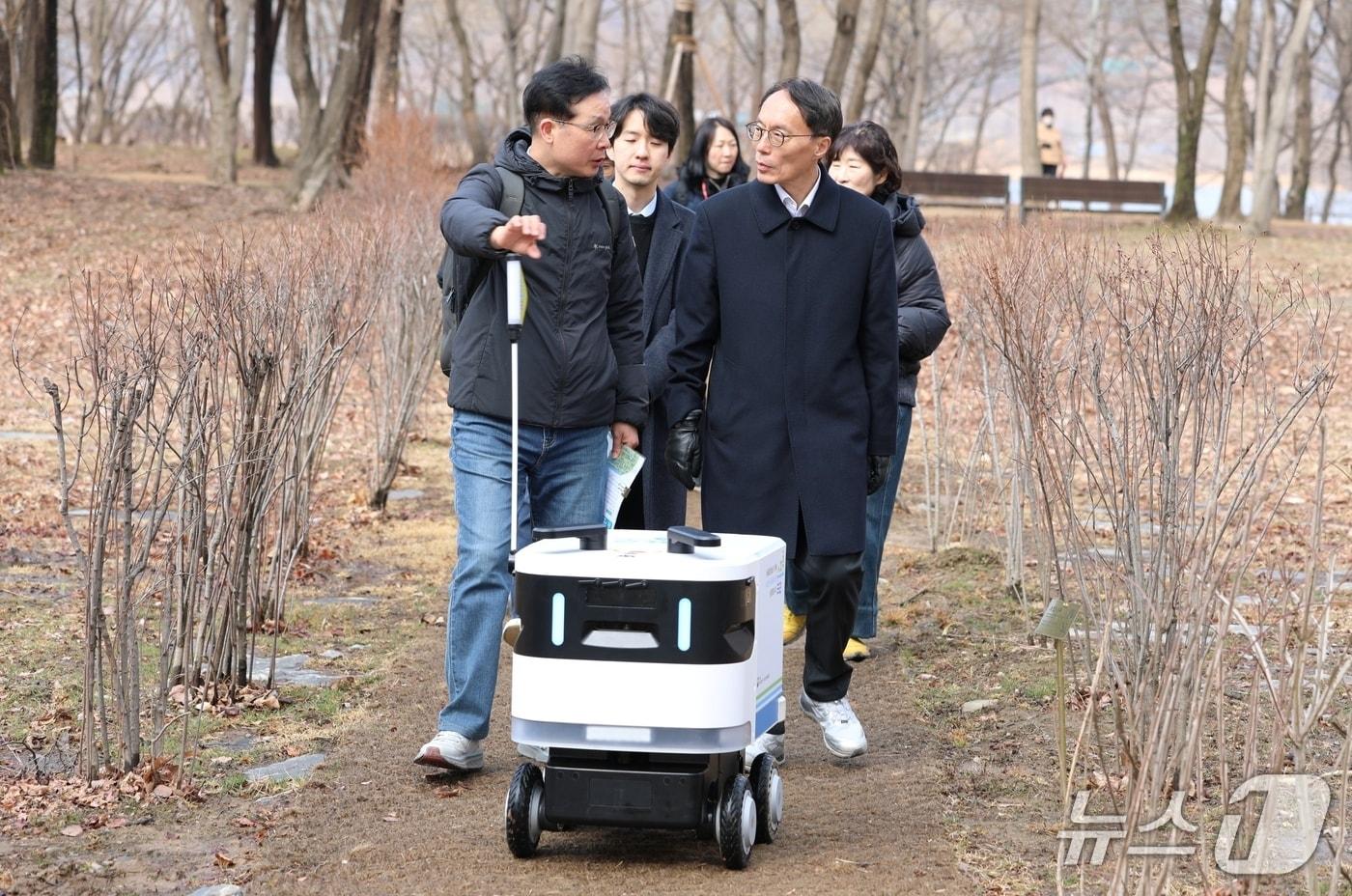본문 이미지 - 이승환 청장(오른쪽)이 6일 경기 양평군 수풀로 양수리에서 순찰·홍보를 담당하는 AI로봇 ‘수풀로버’의 가동 상태를 확인하고 있다.(한강청 제공)