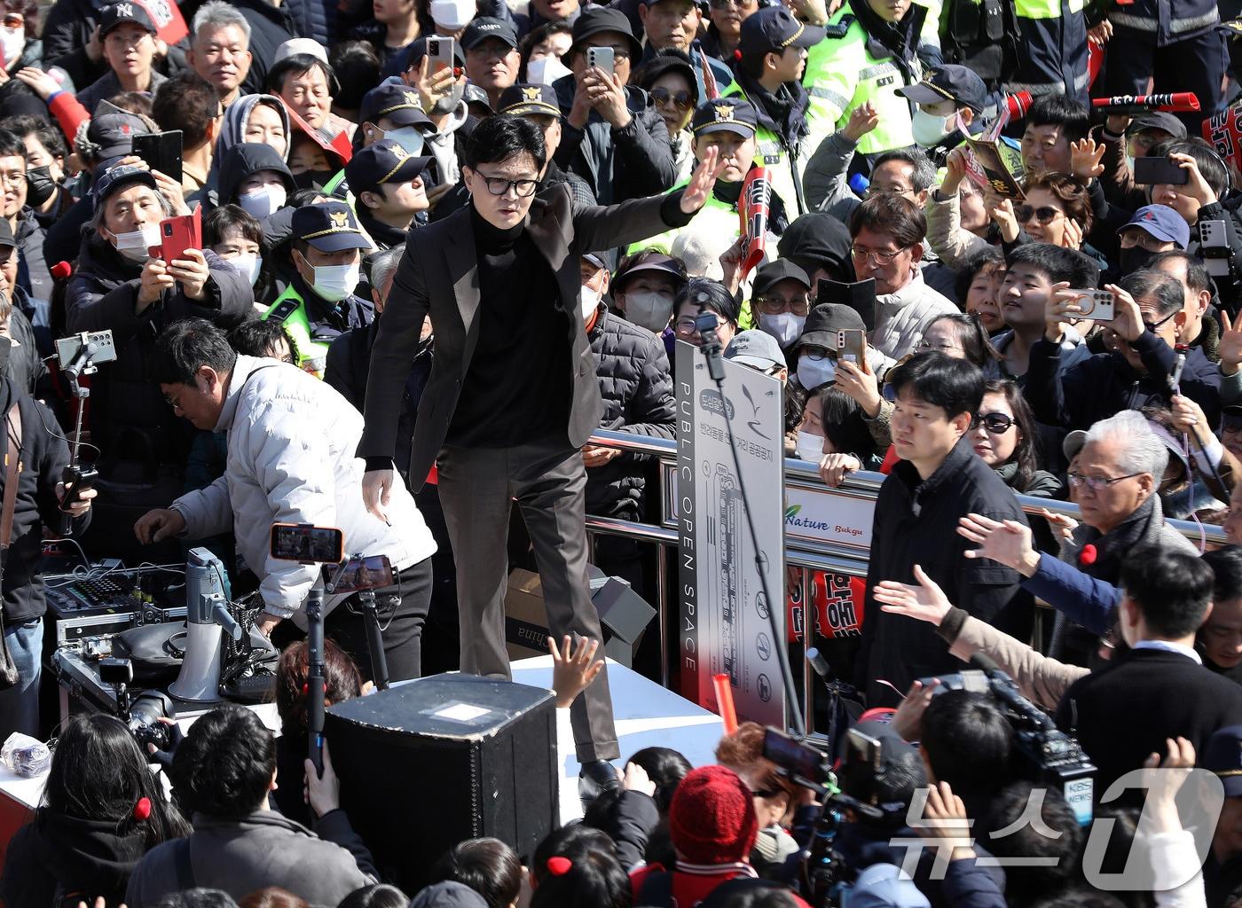 본문 이미지 - 한동훈 전 국민의힘 대표가 지난 3월 7일 오후 부산 북구 구포시장을 찾아 지지자들에게 손을 흔들고 있다. 2026.3.7 ⓒ 뉴스1 윤일지 기자
