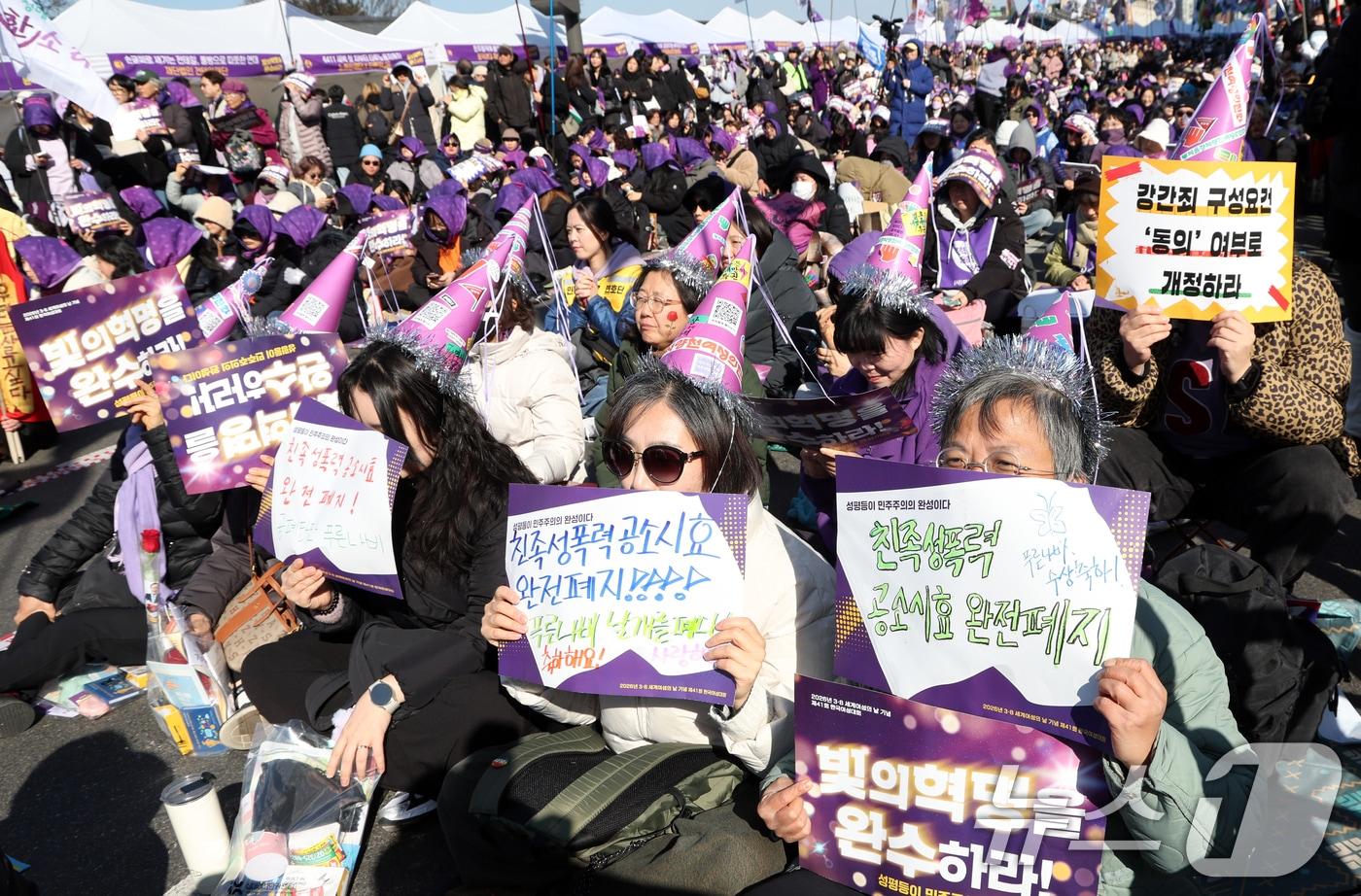 본문 이미지 - 7일 서울 광화문 서십자각에서 열린 2026년 3·8세계여성읜 날 기념 제41회 한국여성대회에서 참가자들이 구호를 외치고 있다. 이번 대회는 '빛의 혁명을 완수하라! 성평등이 민주주의의 완성이다 모이자광장으로, 여성주권자의 힘으로!'라는 슬로건으로 열렸다 2026.3.7 ⓒ 뉴스1 김명섭 기자