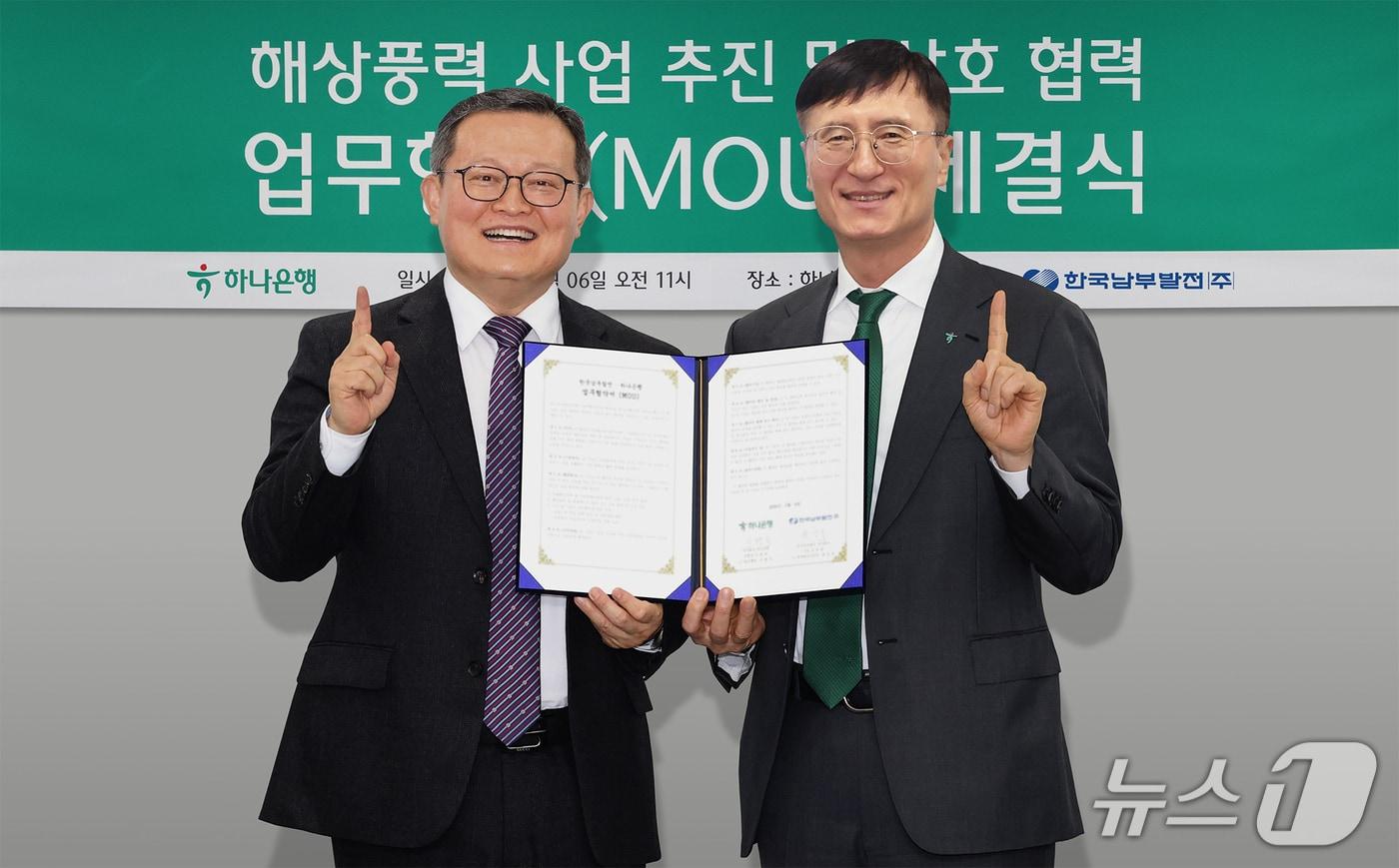 본문 이미지 - 하나은행은 지난 6일 한국남부발전과 해상풍력 발전사업 공동개발 및 재생에너지로의 대전환을 위한 업무협약을 체결했다. 이날 협약식에 참석한 이병식 하나은행 IB그룹 부행장(사진 오른쪽)이 윤상옥 한국남부발전 재생에너지전무(사진 왼쪽)와 함께 협약서를 들고 기념촬영을 하고 있다./사진제공=하나은행