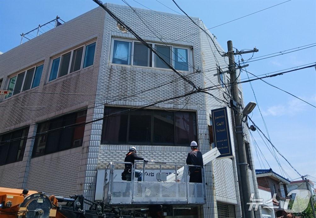본문 이미지 - 주인 없는 노후 간판을 철거하고 있는 제주시 관계자들.(제주시 제공, 재판매 및 DB 금지)