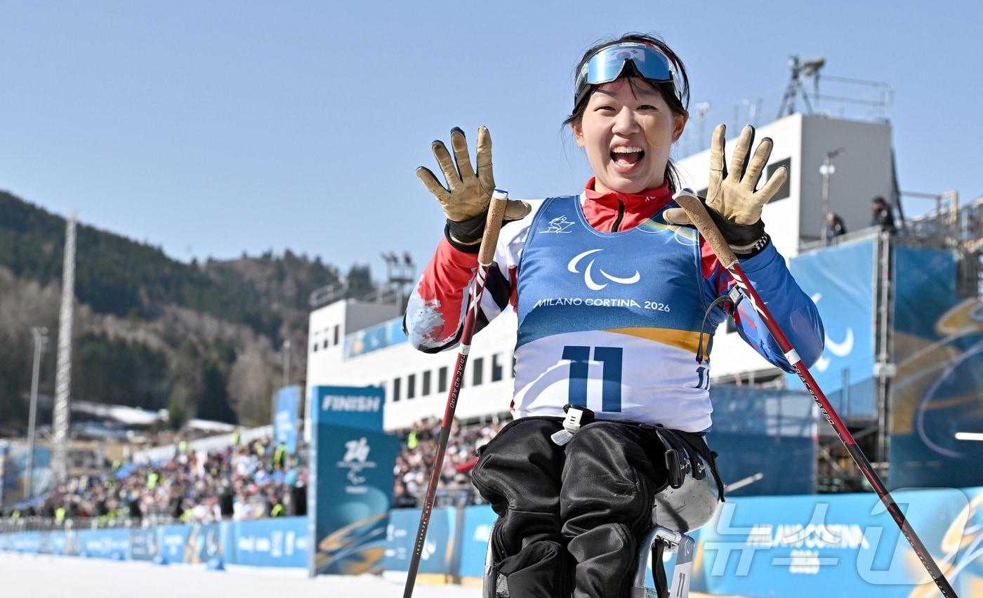 본문 이미지 - 바이애슬론 김윤지가 8일(현지시간) 이탈리아 테세로 크로스컨트리 스키 스타디움에서 열린 2026 밀라노·코르티나 동계패럴림픽 바이애슬론 여자 스프린트 좌식 12.5km 결선에서 금메달을 차지한 뒤 미소 짓고 있다. 2026.3.8 ⓒ 뉴스1 사진공동취재단