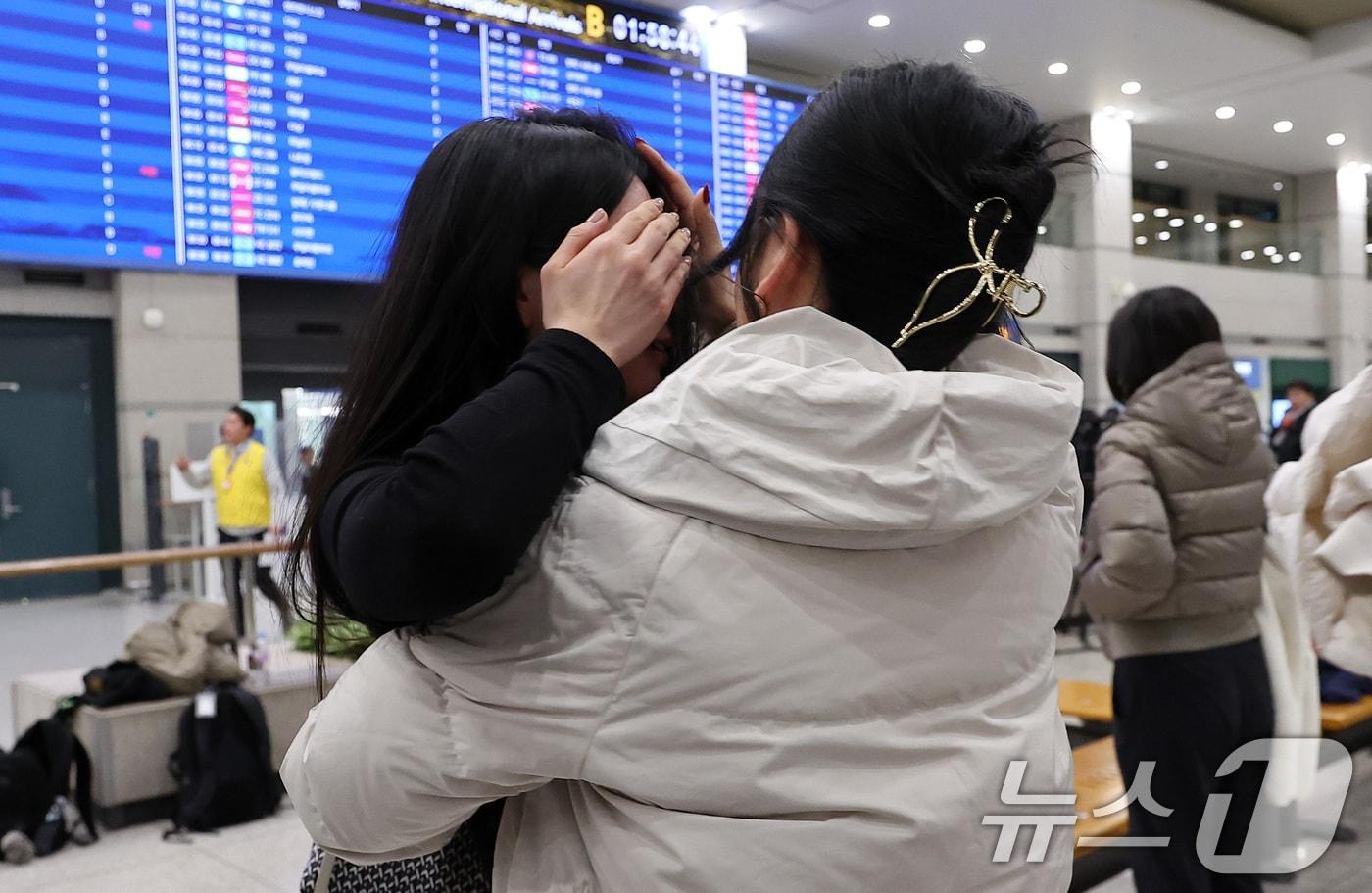 본문 이미지 - '중동 상황' 장기화로 인해 정부에서 추진한 전세기를 타고 아랍에미리트(UAE)에서 출발해 9일 새벽 인천국제공항을 통해 귀국한 승객들이 가족들과 포옹을 하고 있다. 2026.3.9 ⓒ 뉴스1 김성진 기자