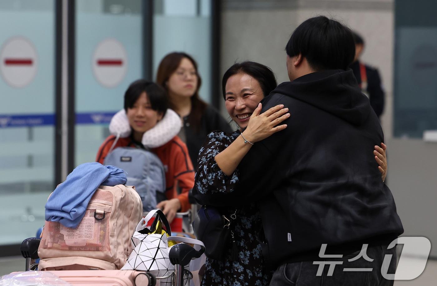 본문 이미지 - '중동 상황' 장기화로 인해 정부에서 추진한 전세기를 타고 아랍에미리트(UAE)에서 출발해 9일 새벽 인천국제공항을 통해 귀국한 승객들이 가족들과 포옹을 하고 있다. 2026.3.9 ⓒ 뉴스1 김성진 기자